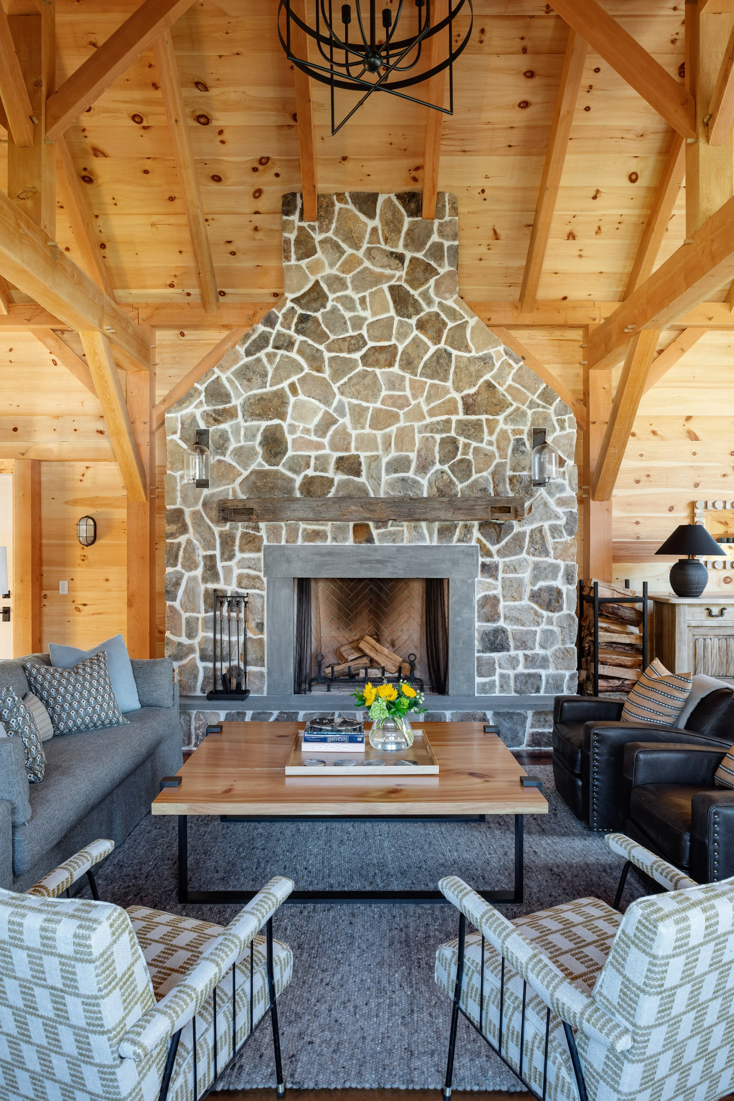 Family room interior by Good Bones Design with warm wood, a lot of light, stone fireplace and blue, gray and tan accents