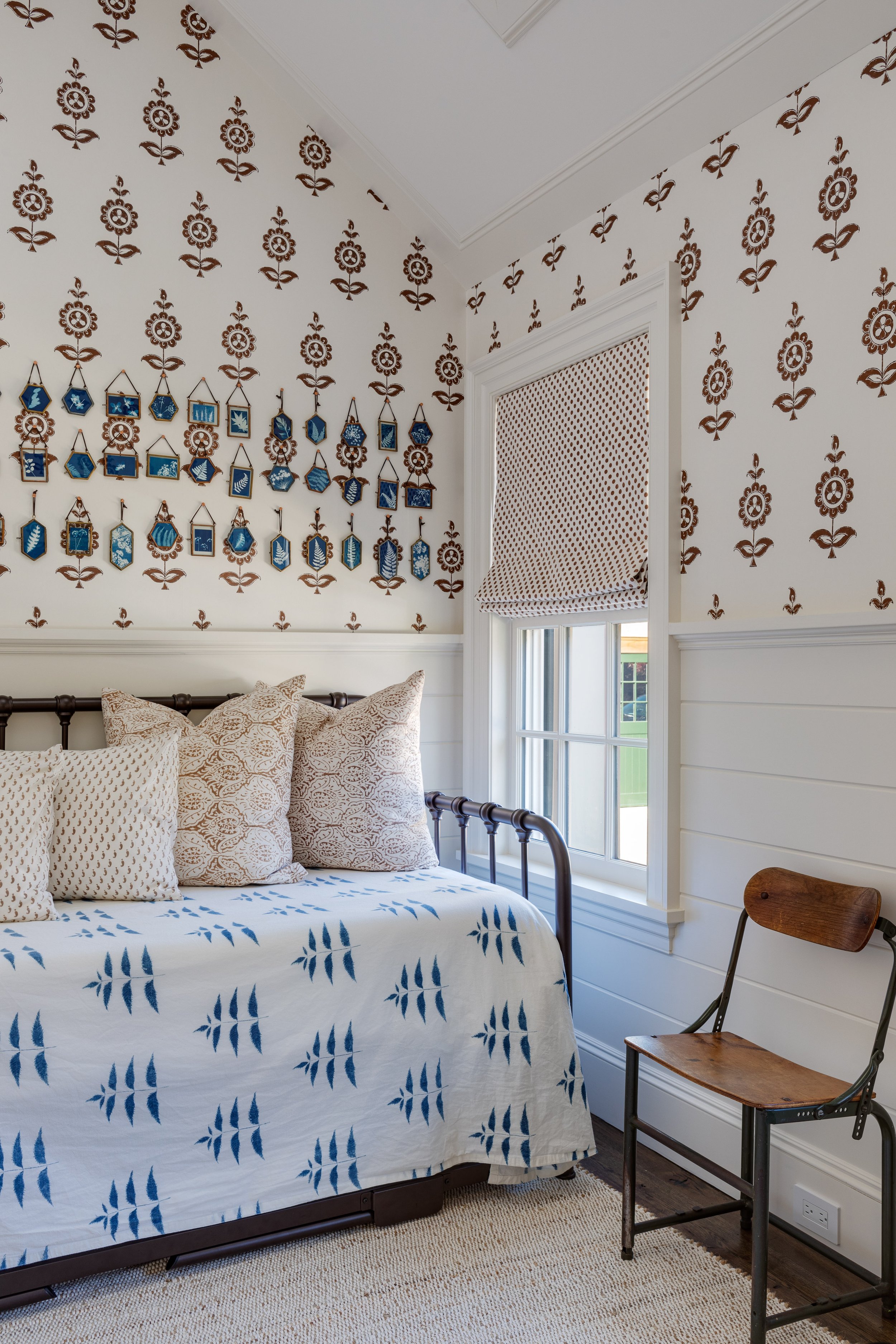 Bedroom nook interior by Good Bones Design with fun patterned wall paper, tans and blues