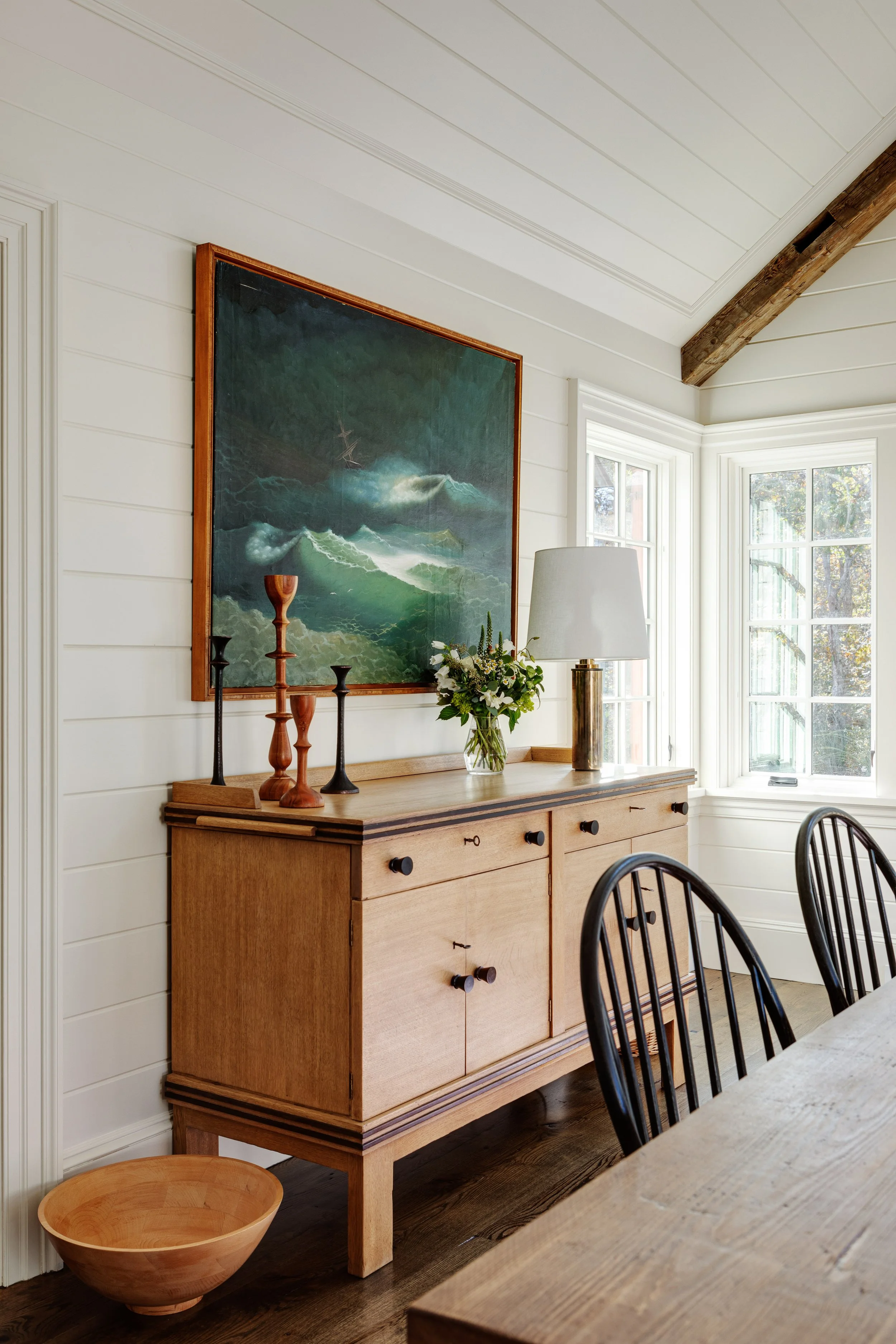 Detail of dining room interior by Good Bones Design with warm wood and bright light