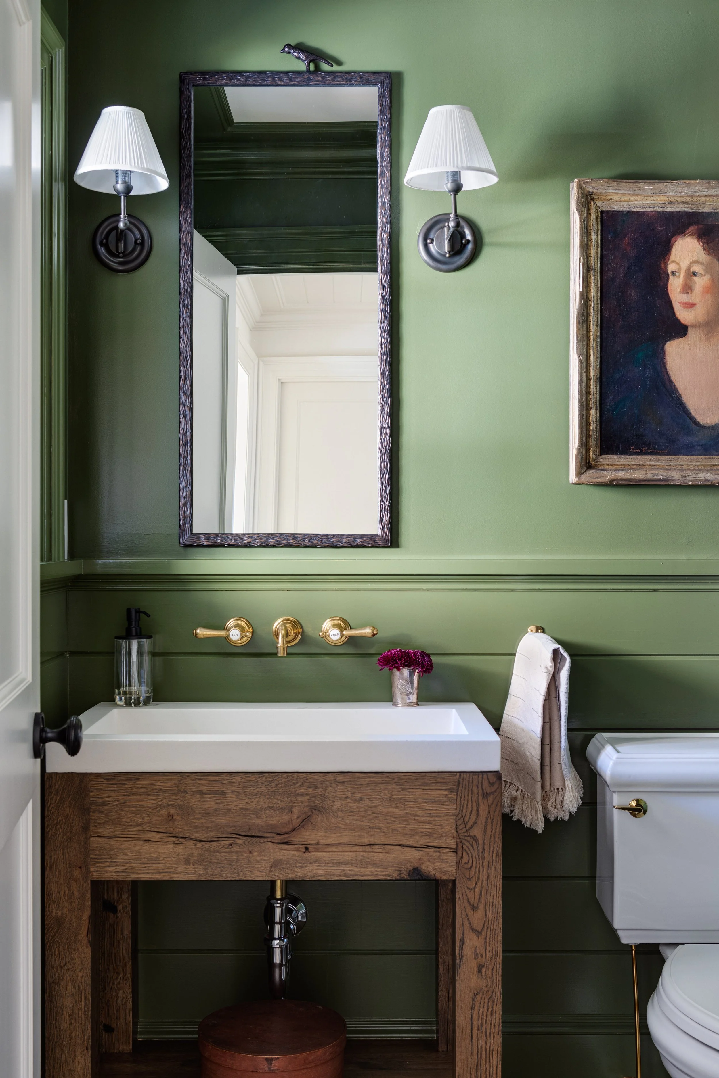 Powder room by Good Bones Design with green painted walls, custom wood vanity and soft accents