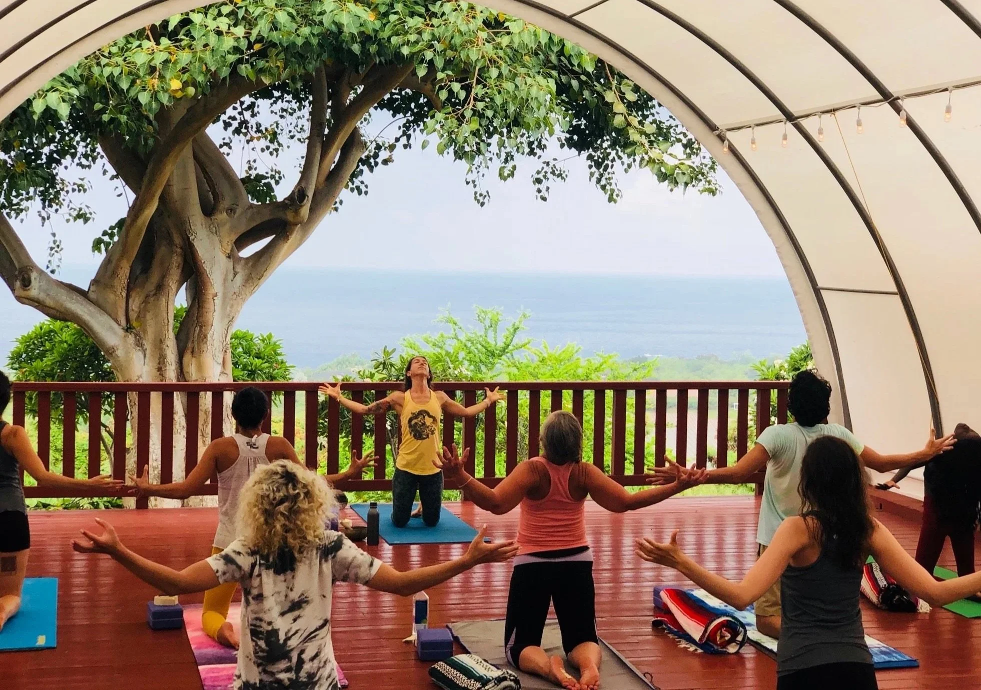Group yoga practice in Konalani’s open-air yoga space overlooking the ocean.