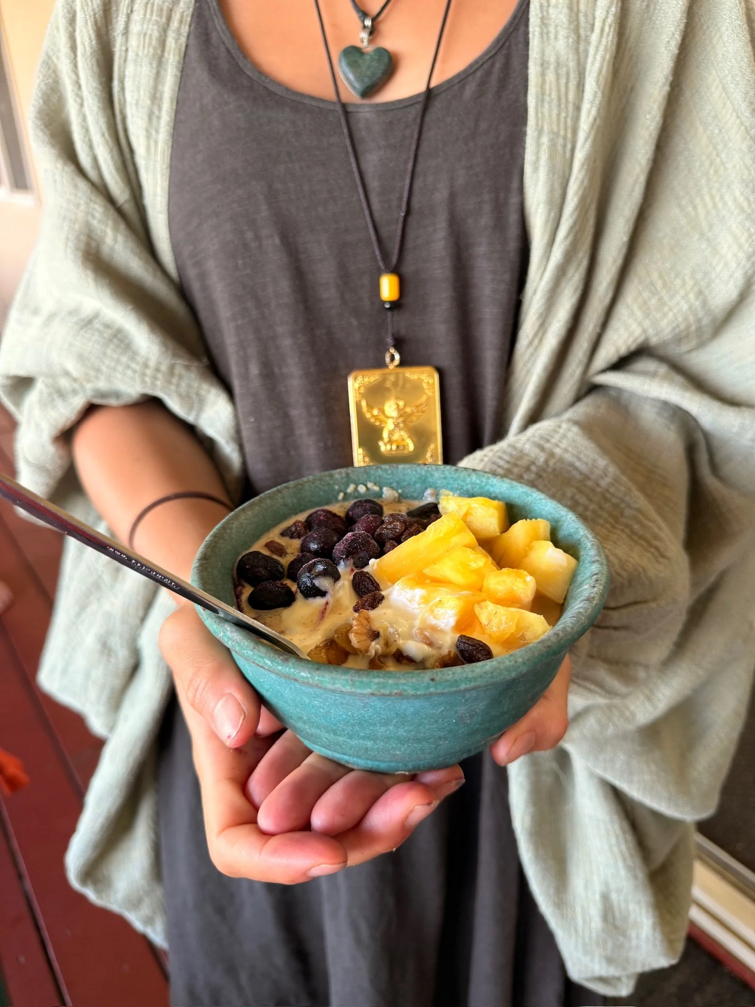 A bowl of breakfast cereal topped with mango and dried fruit.