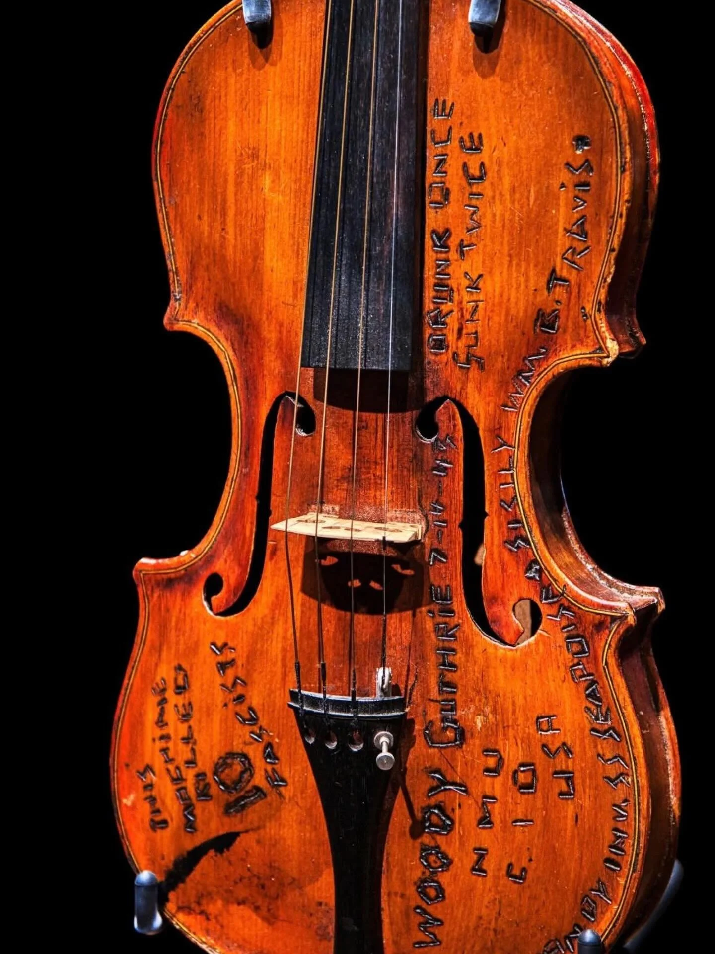 Woody Guthrie&rsquo;s fiddle, inscribed with mottos and the names of the ships he served on in the Merchant Marines in WWII.
What is defacement, and what is glorious history? Personally, I love it.