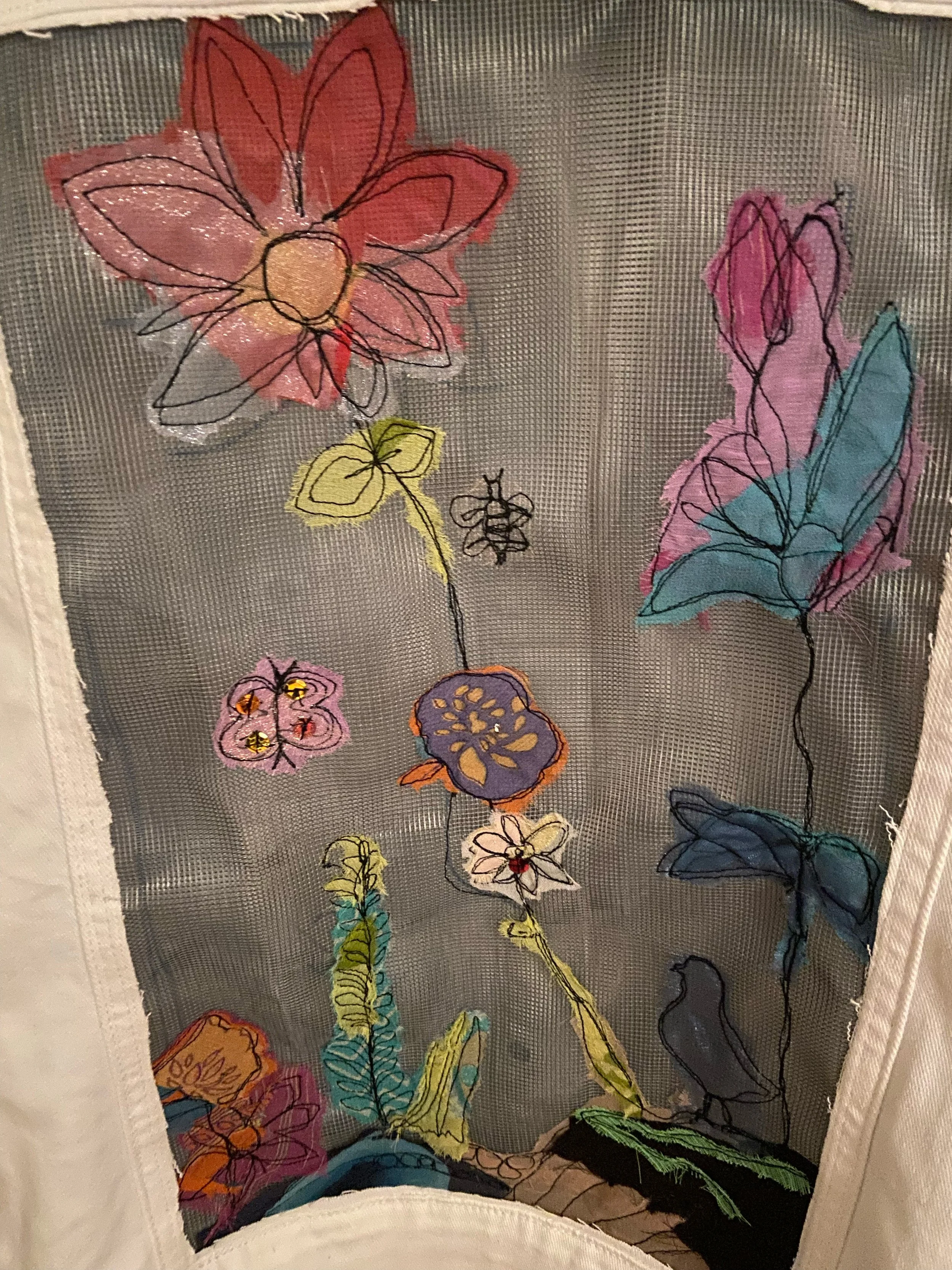 Women's size Large white denim jacket with garden scene on back yoke, including rocks, bird, butterfly, bee, multiple flowers. In stock
