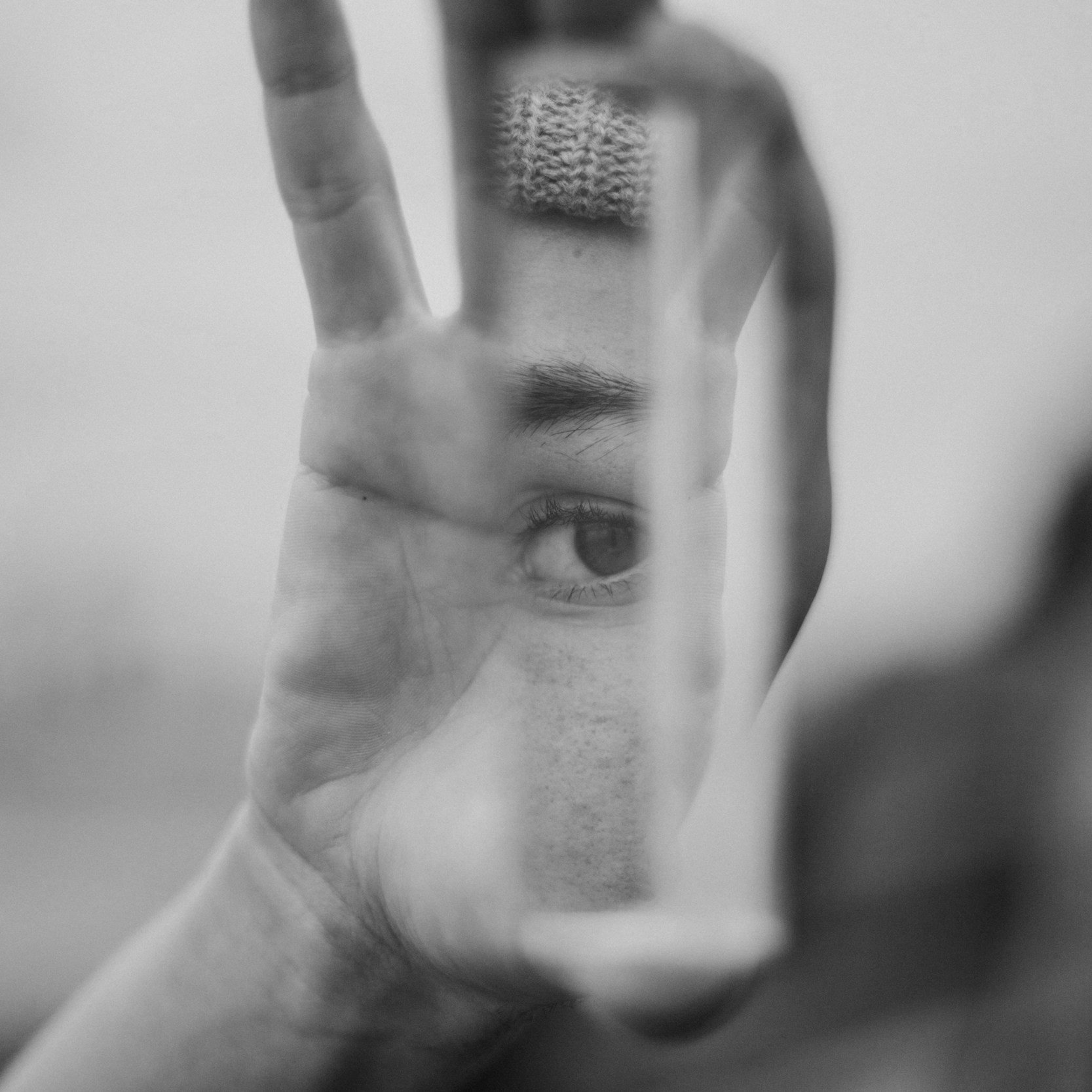 black and grey hand holding mirror reflecting eye