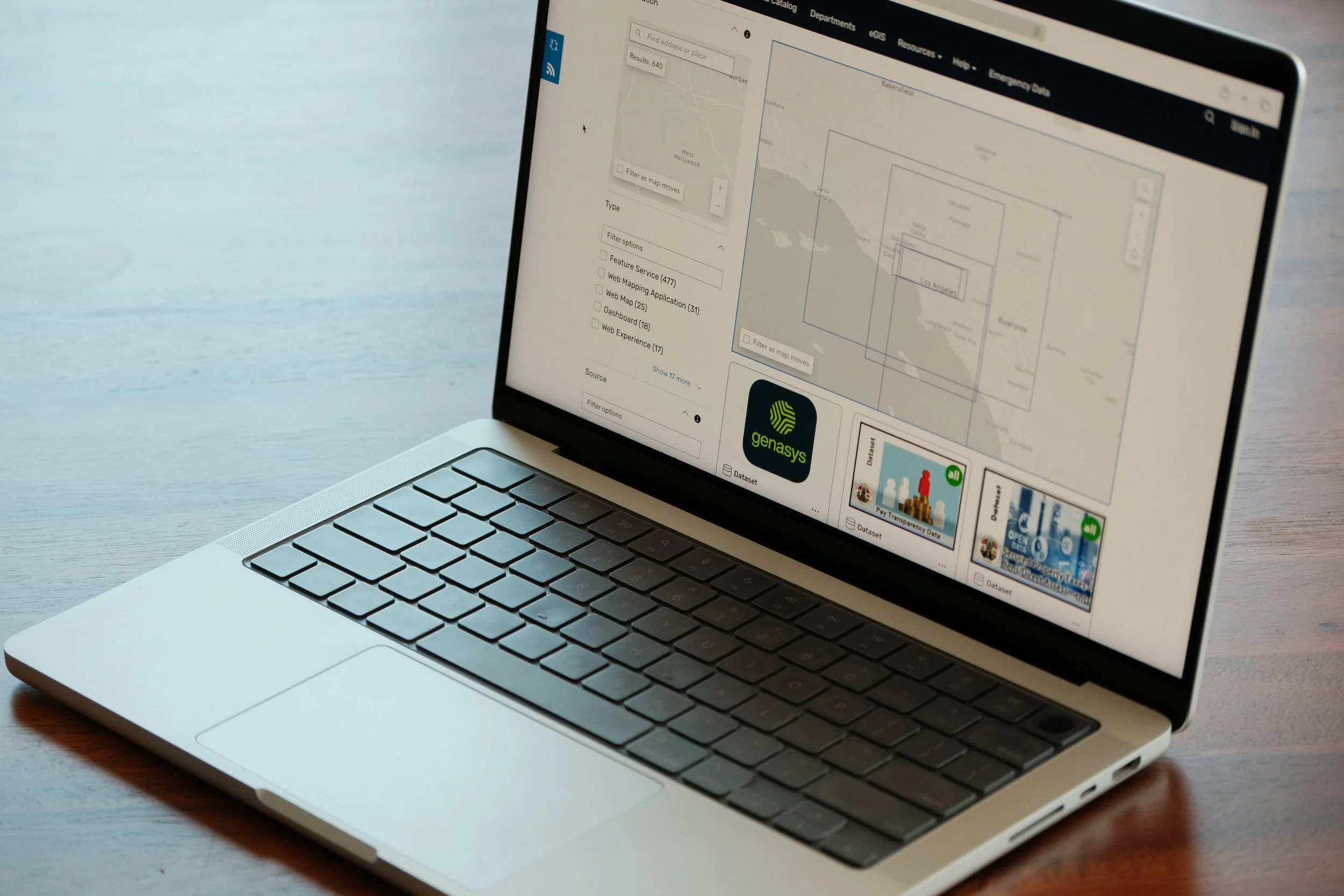Laptop displaying analytics dashboard with graphs and charts on a glass table.
