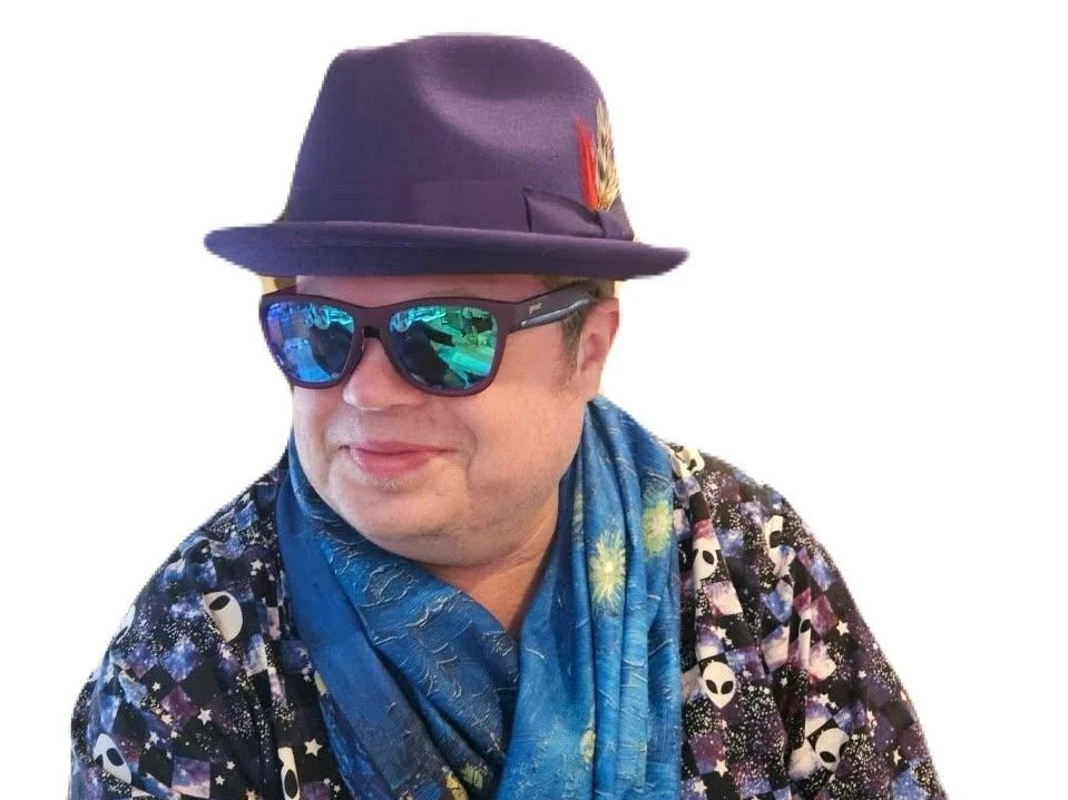 A smiling male student in a hat and sunglasses