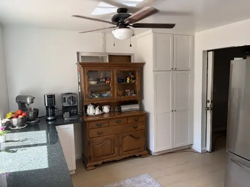 Remodeled kitchen with white cabinets and dark countertop in Redding