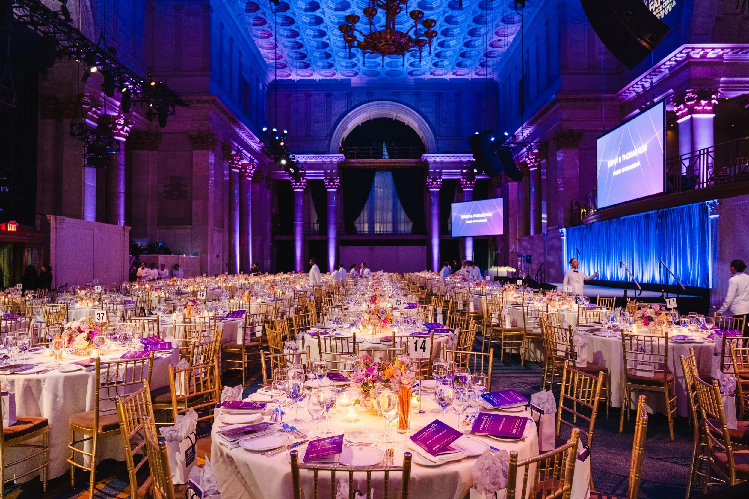Elegant ballroom setup with purple ambient lighting and decorated dining tables for the annual KAFSC Gala.