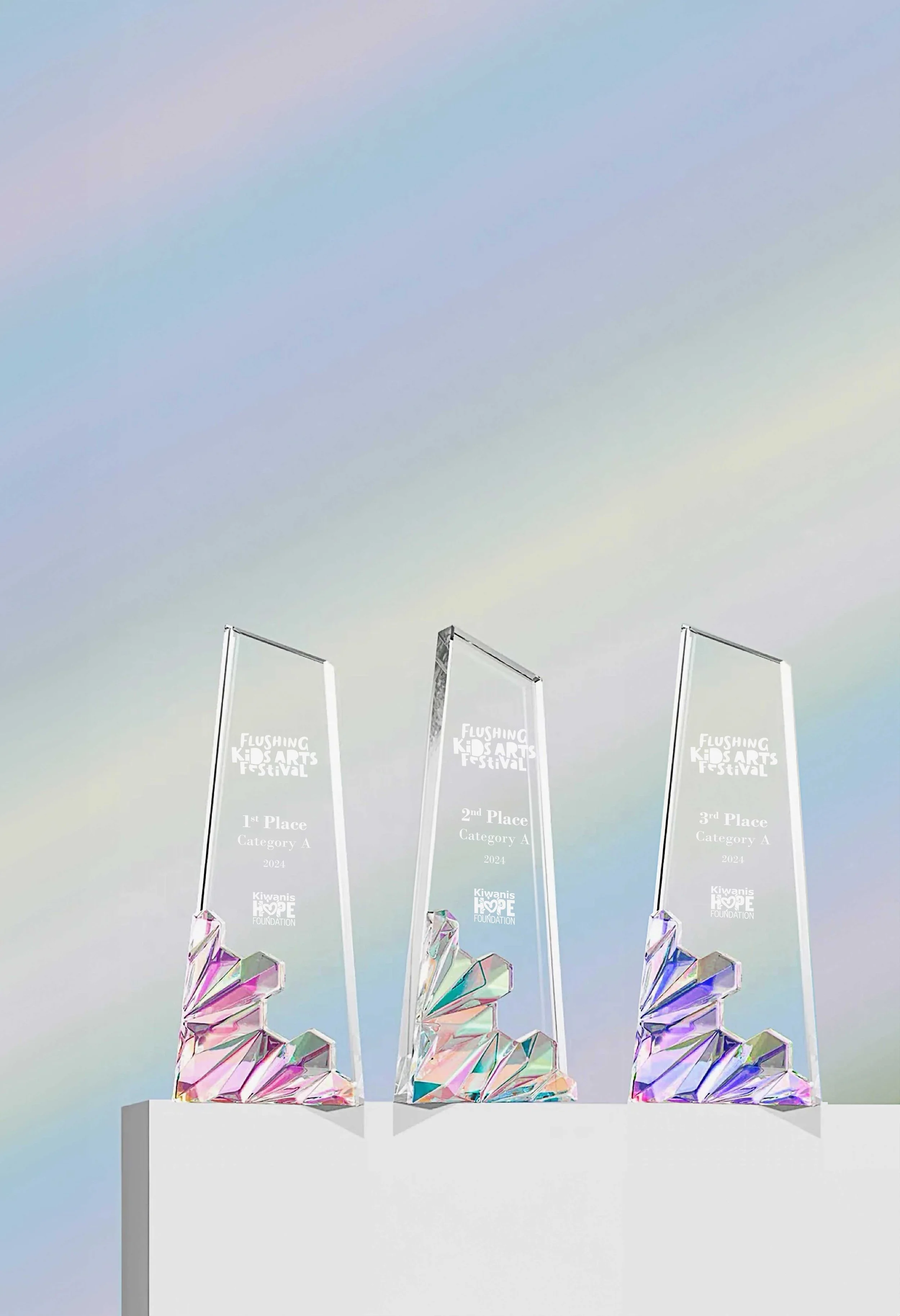 Three crystal custom throphies for the 2024 Flushing Kids Arts Festival 1st, 2nd, and 3rd place with iridescent bases.