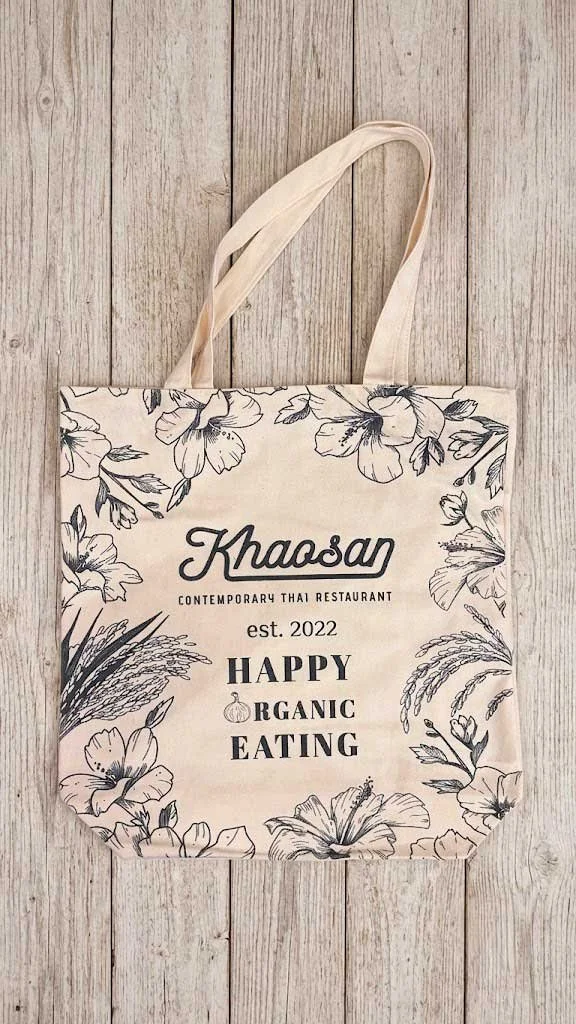 Custom Tote bag with floral sketches for Khaosan Contemporary Thai Restaurant featuring Happy Organic Eating slogan.