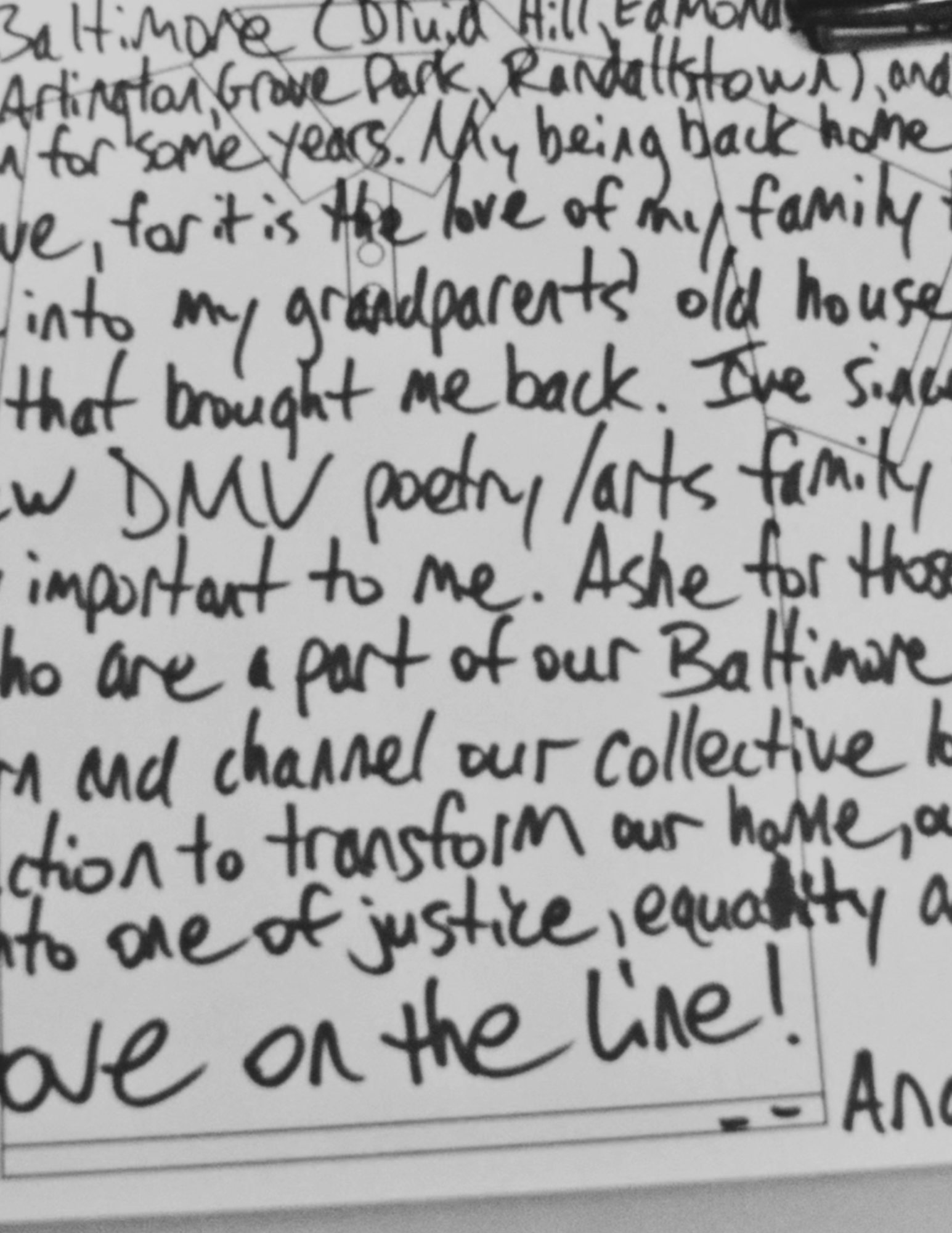 Close-up of handwritten note on a piece of paper with black ink, containing cursive writing.