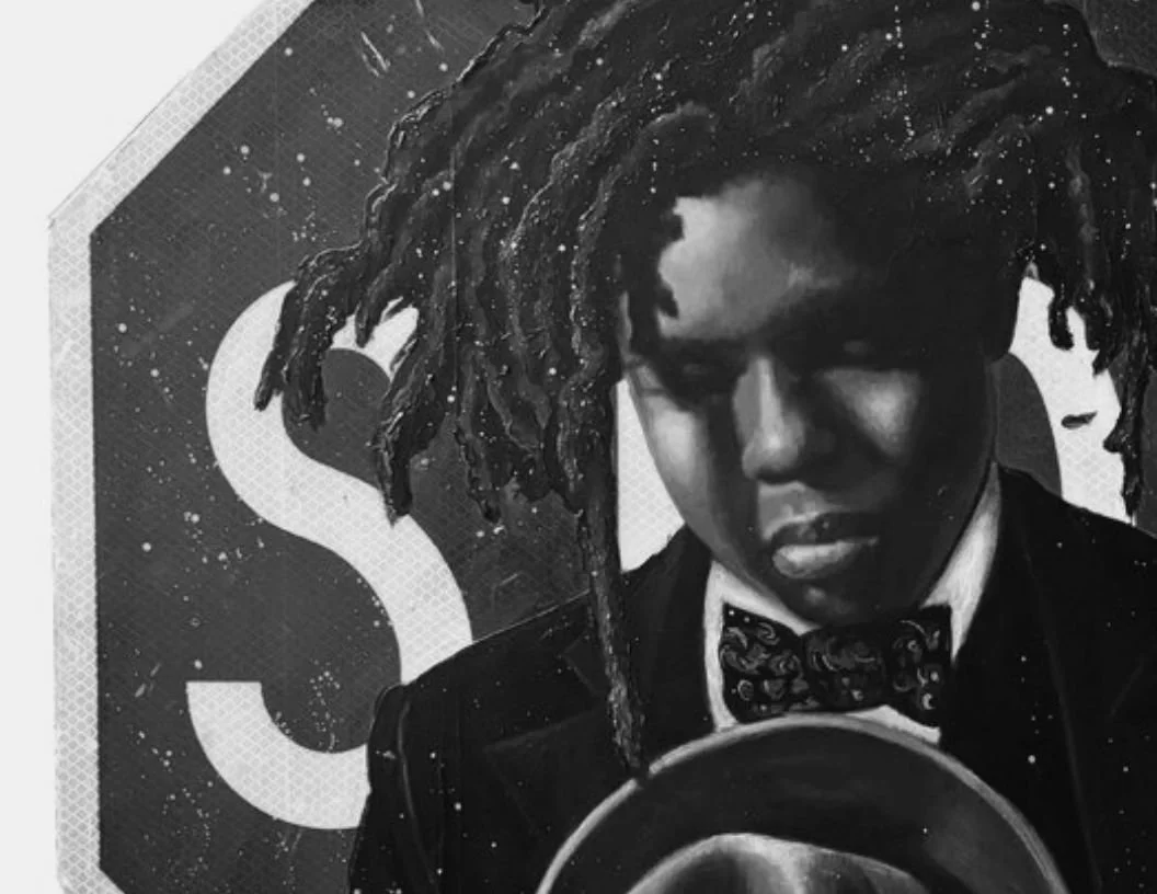 Black and white photo of a person with dreadlocks wearing a tuxedo and bow tie, holding a vinyl record. Behind is a sign with the letter 'S' visible.