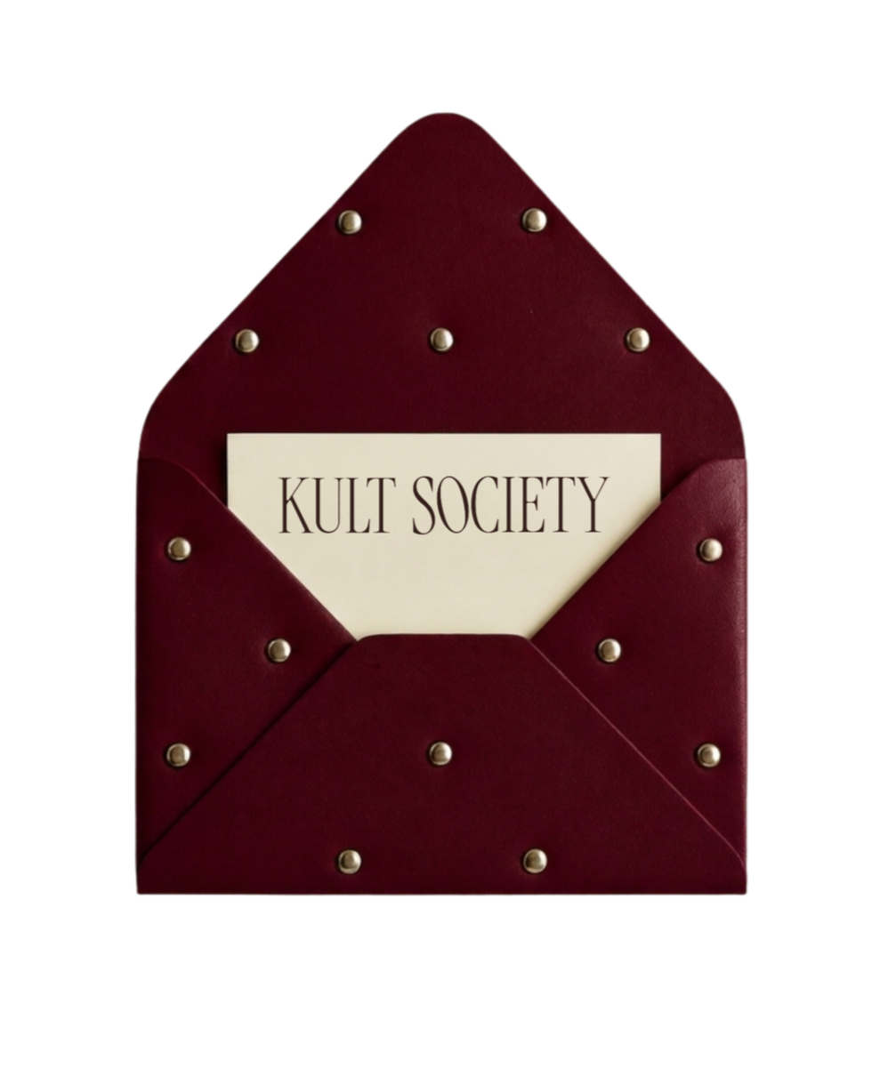 Red leather envelope with metal studs containing a card that reads 'Kult Society'.