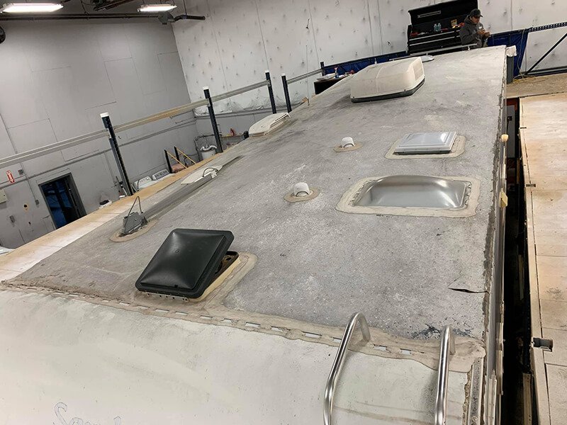 Close-up image showing RV roof damage and deteriorated sealant around roof vents and skylights, a common cause of RV leaks. Liberty RV Roofing specializes in professional RV roof replacement and repair solutions.