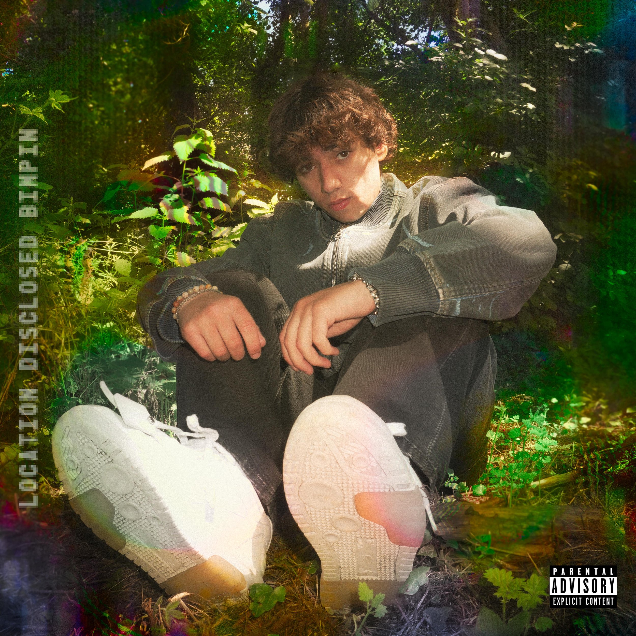 Bimpin sitting in a forest with colorful digital effects, wearing a jacket and white sneakers. Location Disclosed cover art with "Parental Advisory" label.