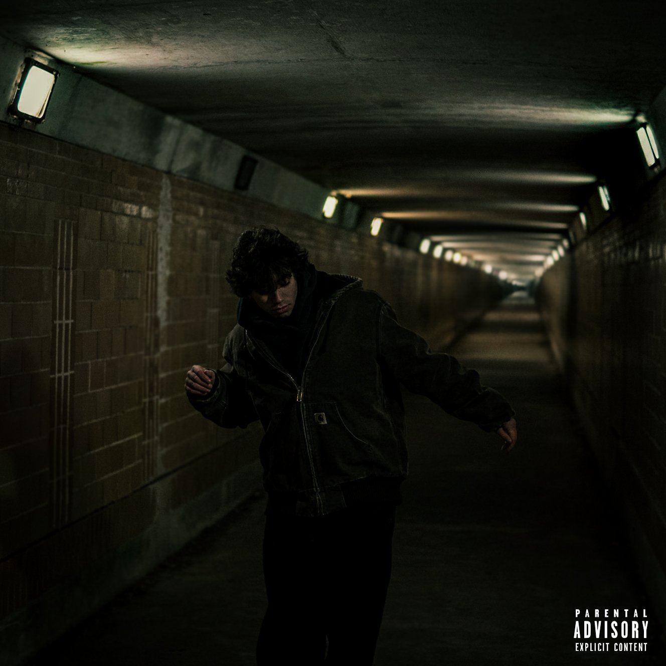 Bimpin in a dimly lit underground tunnel with brick walls. (hate me cover art).
