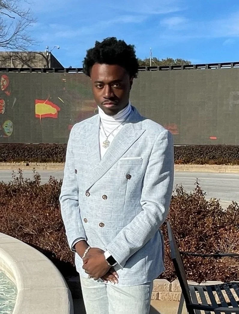 Man in light blue suit standing outdoors