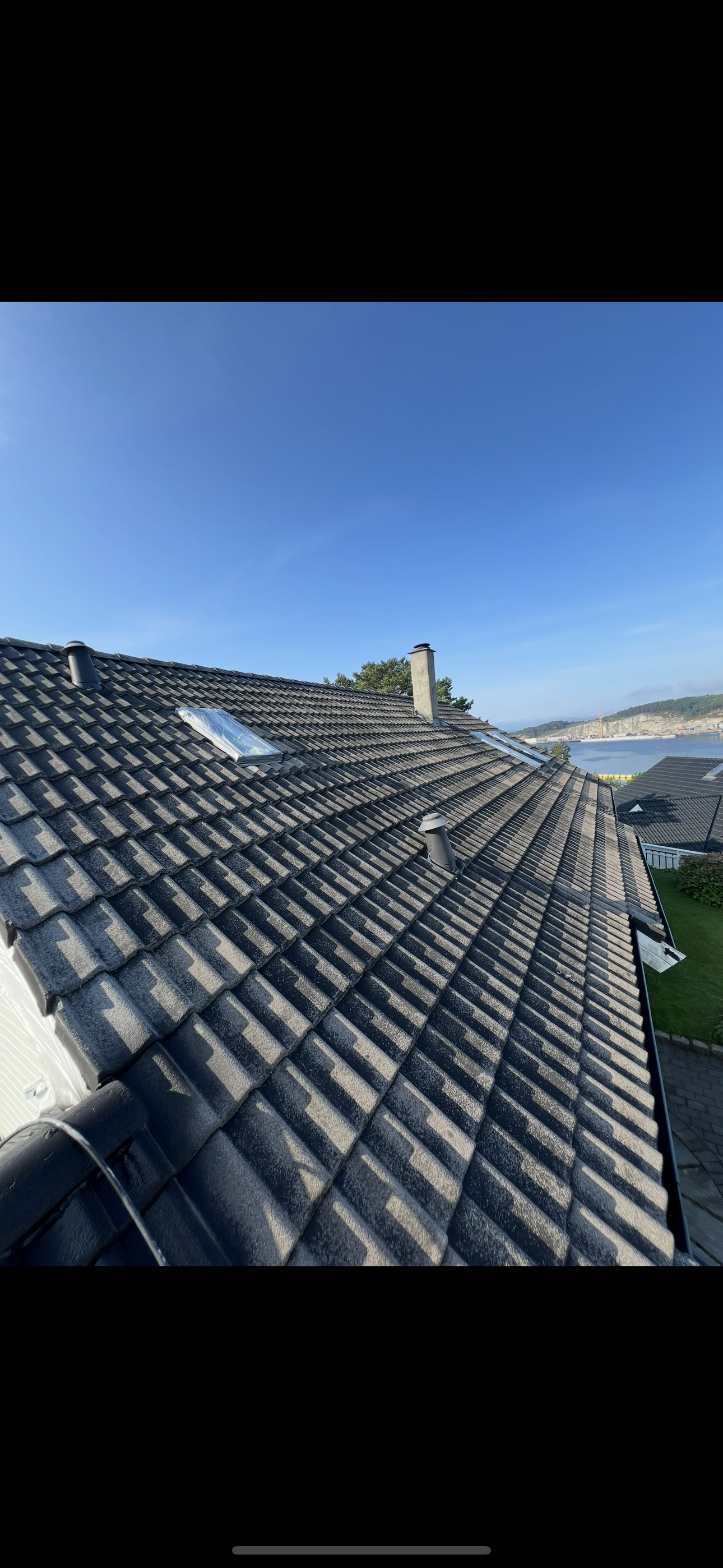 Før takfornying: Slitt grånet svart tak med fjordutsikt i solrikt vær