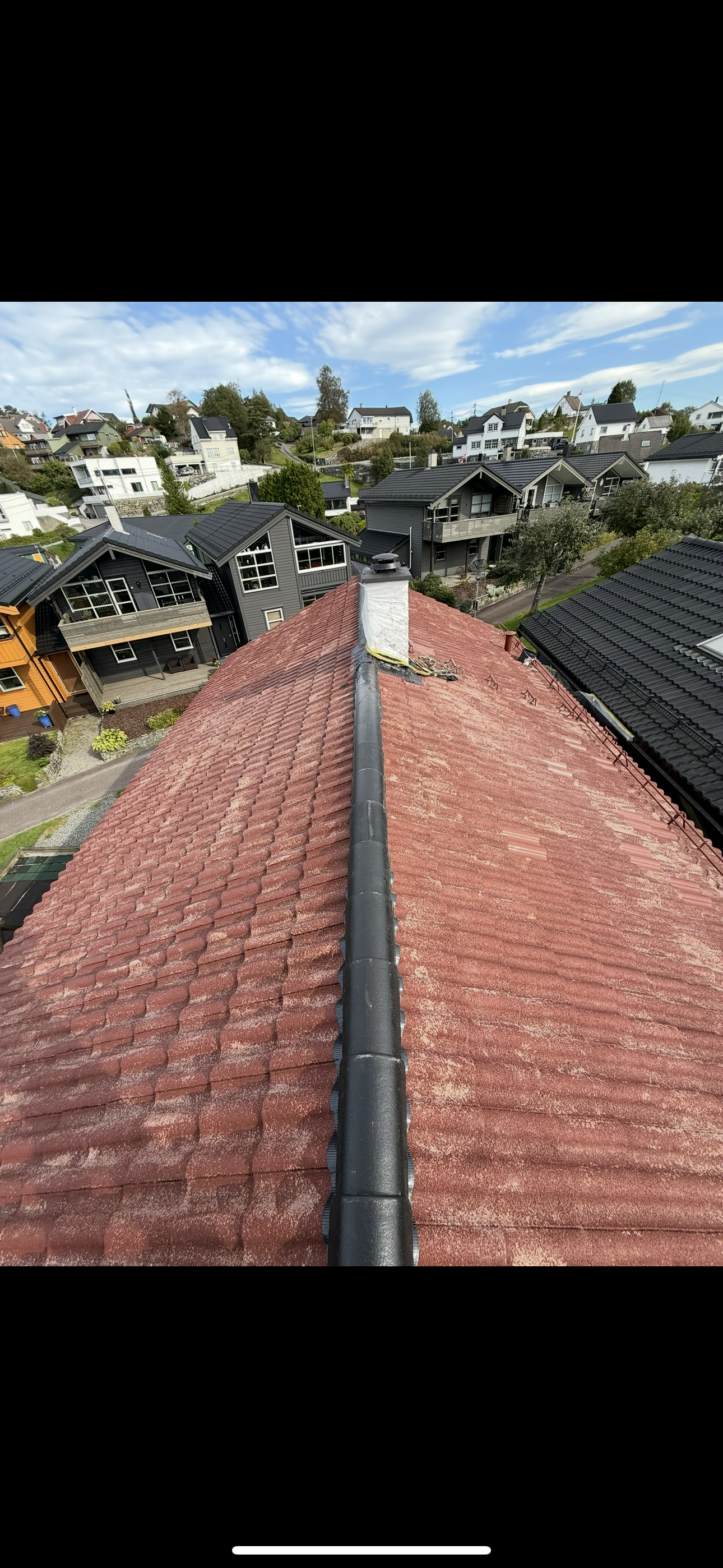 Mellom-bilde: etter vask og montering av nye svarte mønestein på taket i Bergen