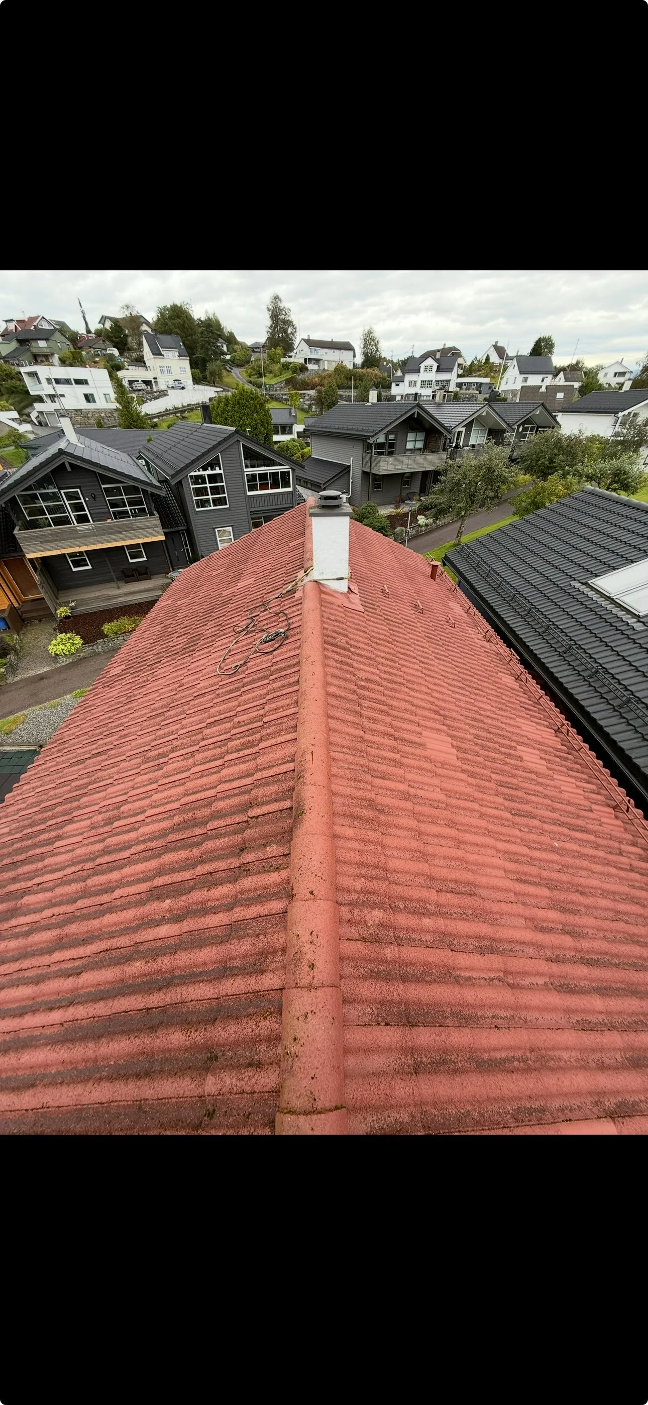 Før-bilde: av slitt rødt tak med mose og skitt før profesjonell takvask og maling i Bergen
