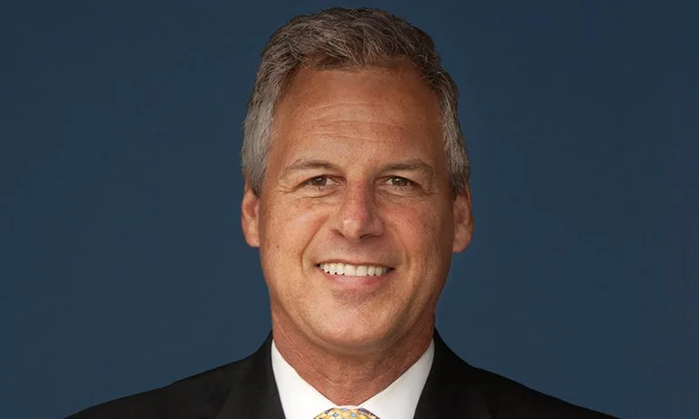 Mark Crowley smiling in a suit and tie, professional leadership keynote speaker portrait
