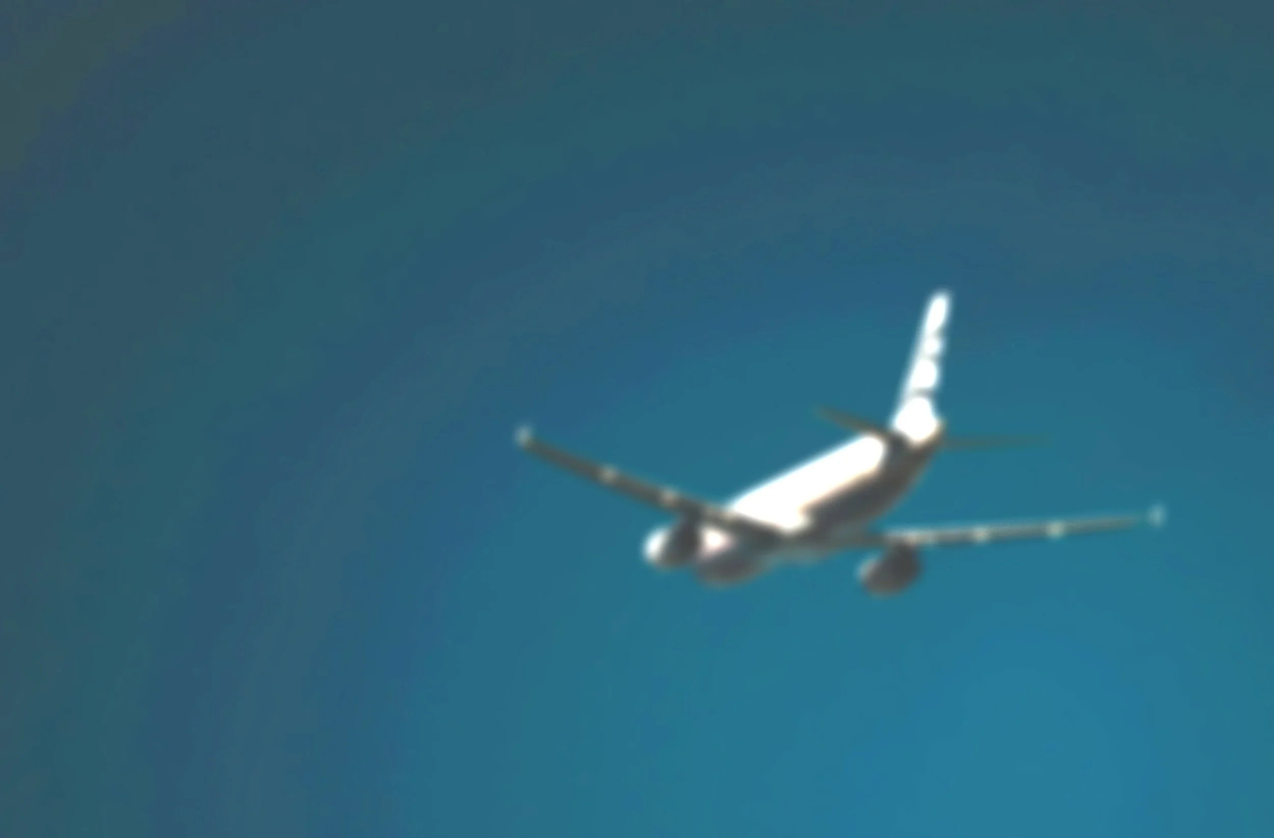 A distant view of an airplane flying in a clear blue sky.