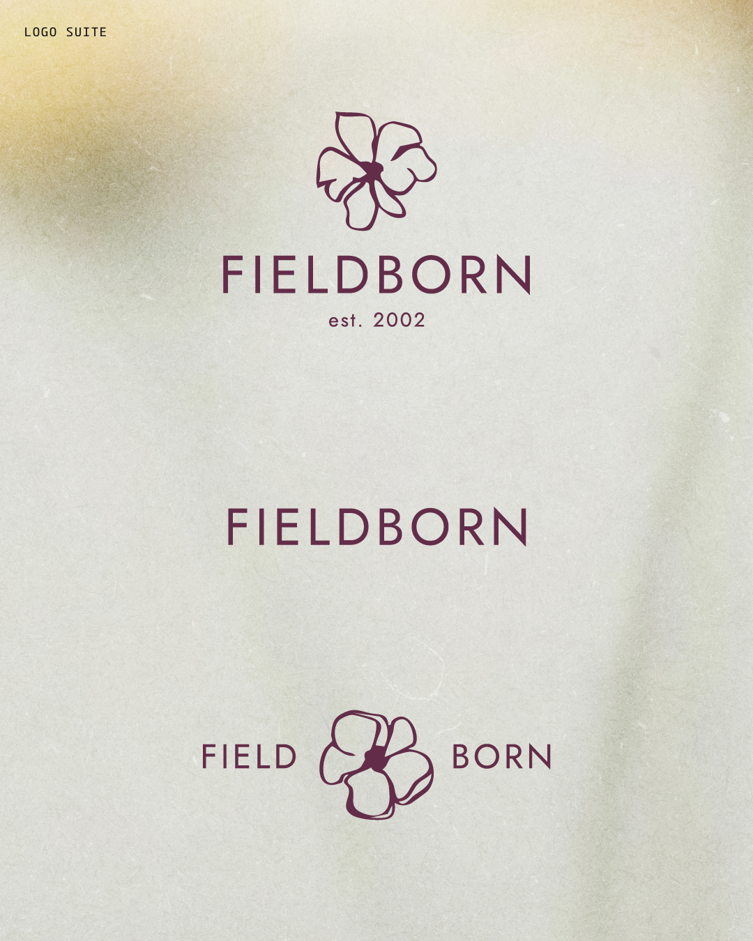 A logo with a flower illustration and the word 'FIELDBORN' underneath, with 'est. 2002' written below; also includes the phrase 'FIELD BORN' with a flower illustration in between.