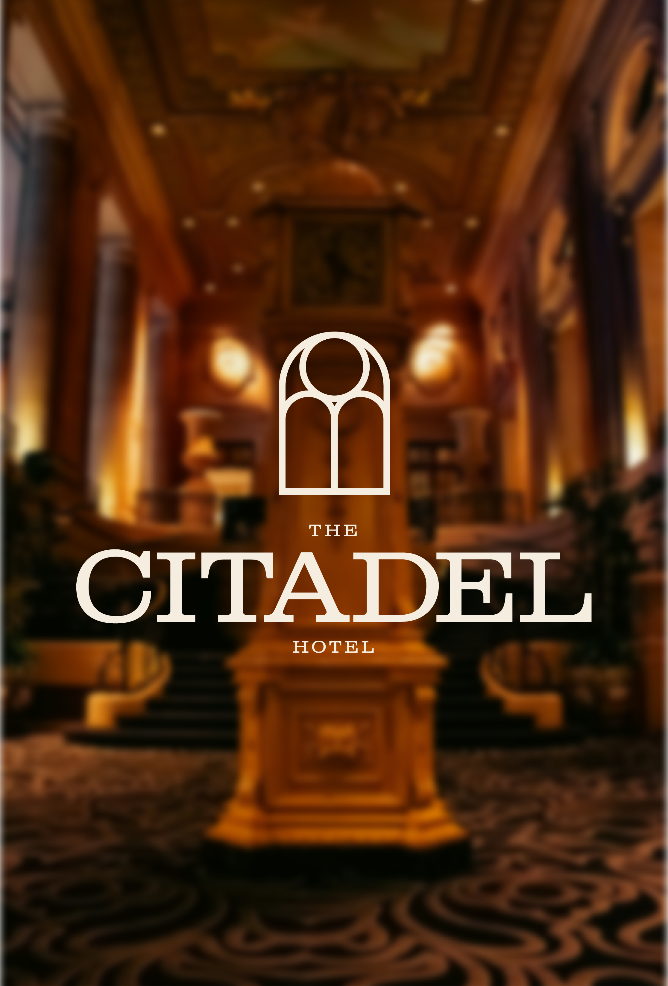 Interior of a luxurious hotel lobby with wooden accents, staircase, and ornate ceiling, with the logo and name 'The Citadel Hotel' overlaid.