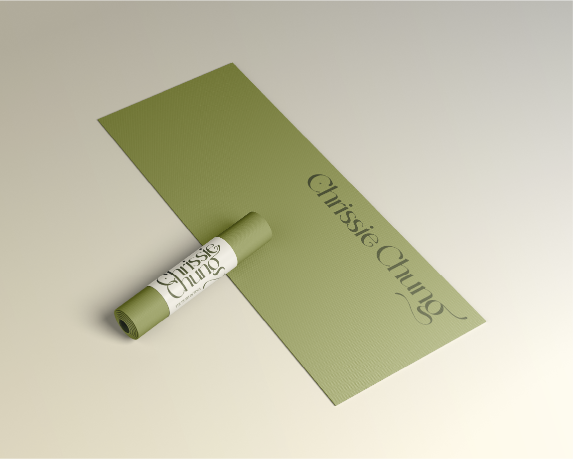 A green yoga mat with the text 'Chrissie Chung' lying on a light-colored surface.