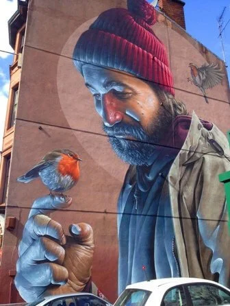 Mural of bearded man with a robin on his finger