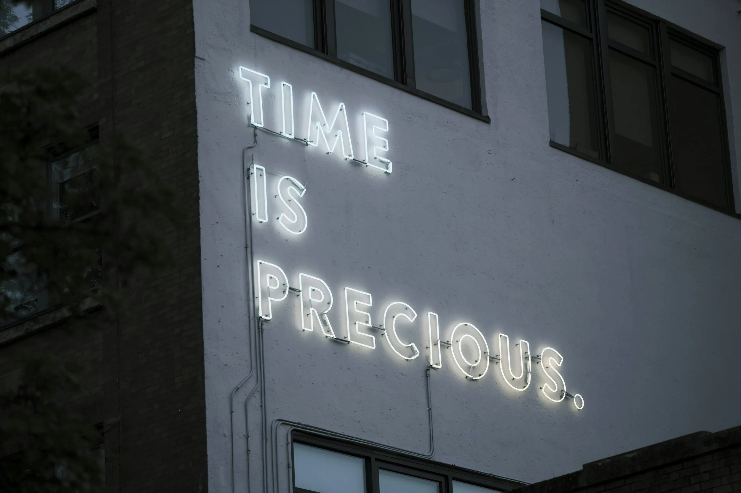 Neon Sign on Building, Sign Says "Time is Precious".
