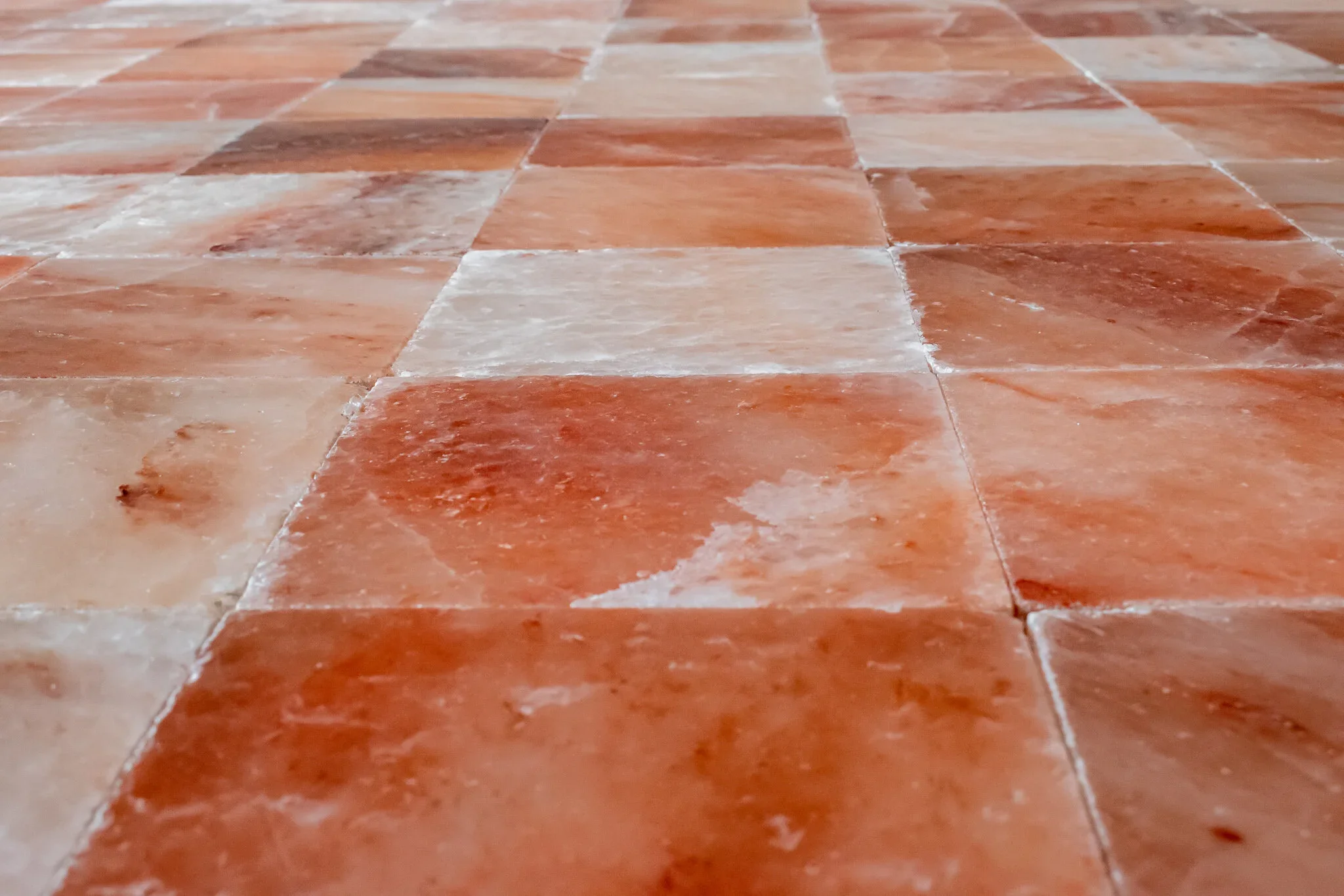 Close-up of a dirt and worn terracotta tiled floor.