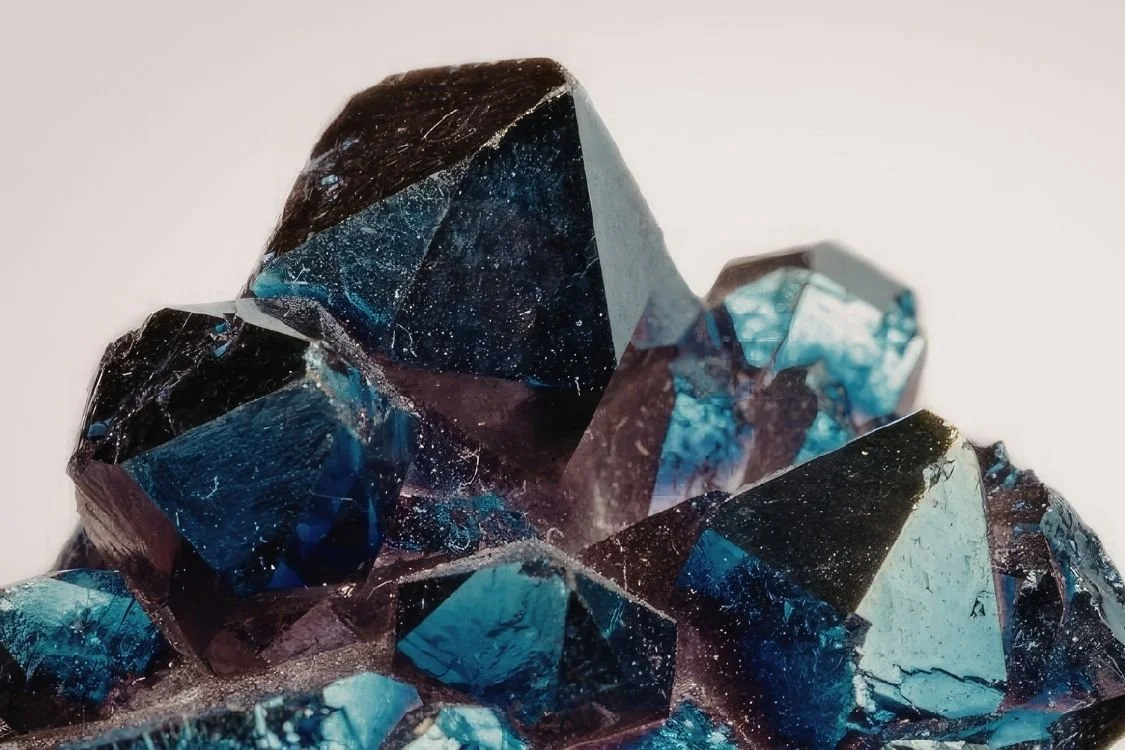 Close-up of dark blue and black crystal formation with reflective surfaces and icy textures.