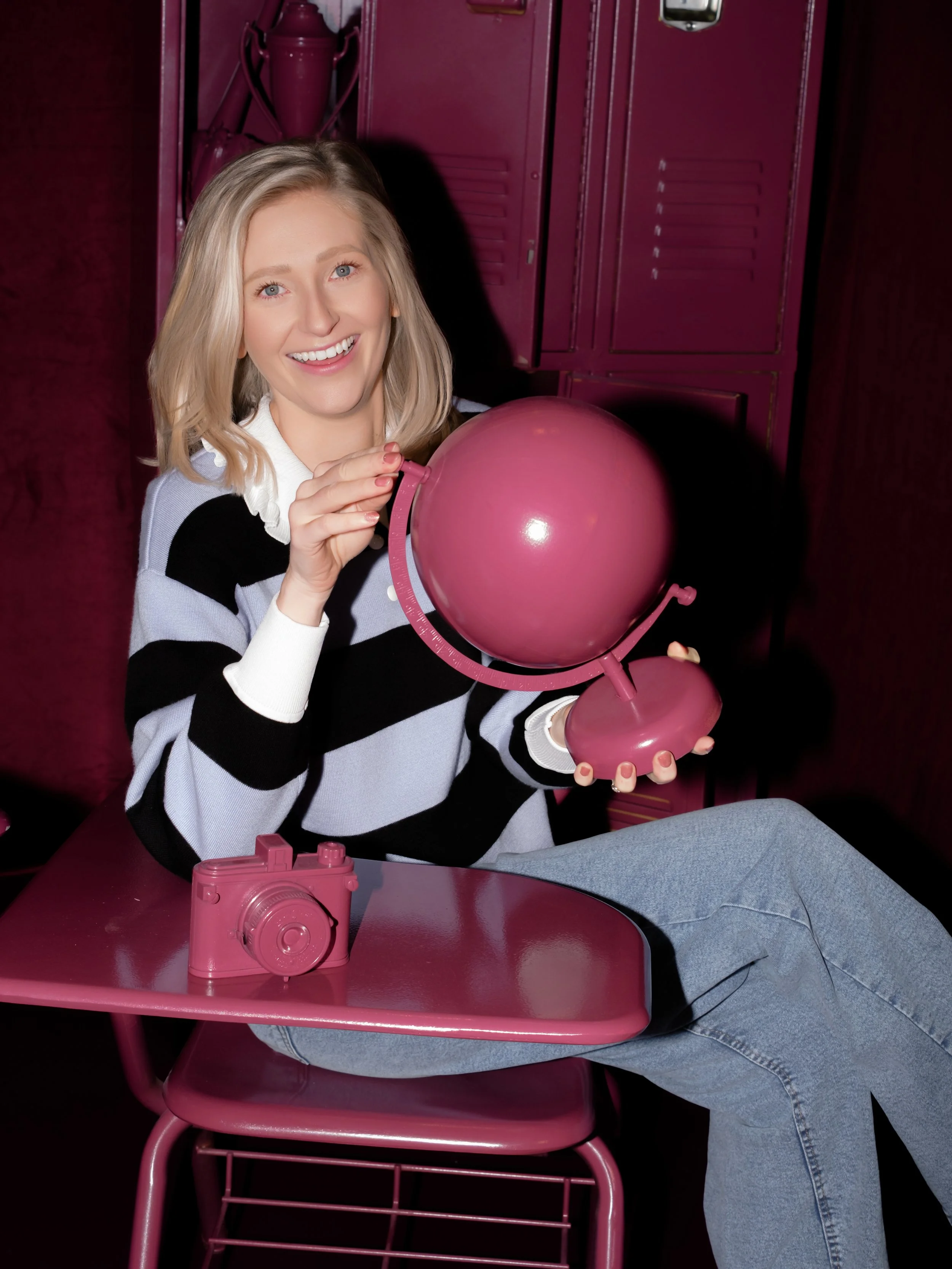 Lauren Maxwell of The Suite Studio holding a pink balloon in a red chair
