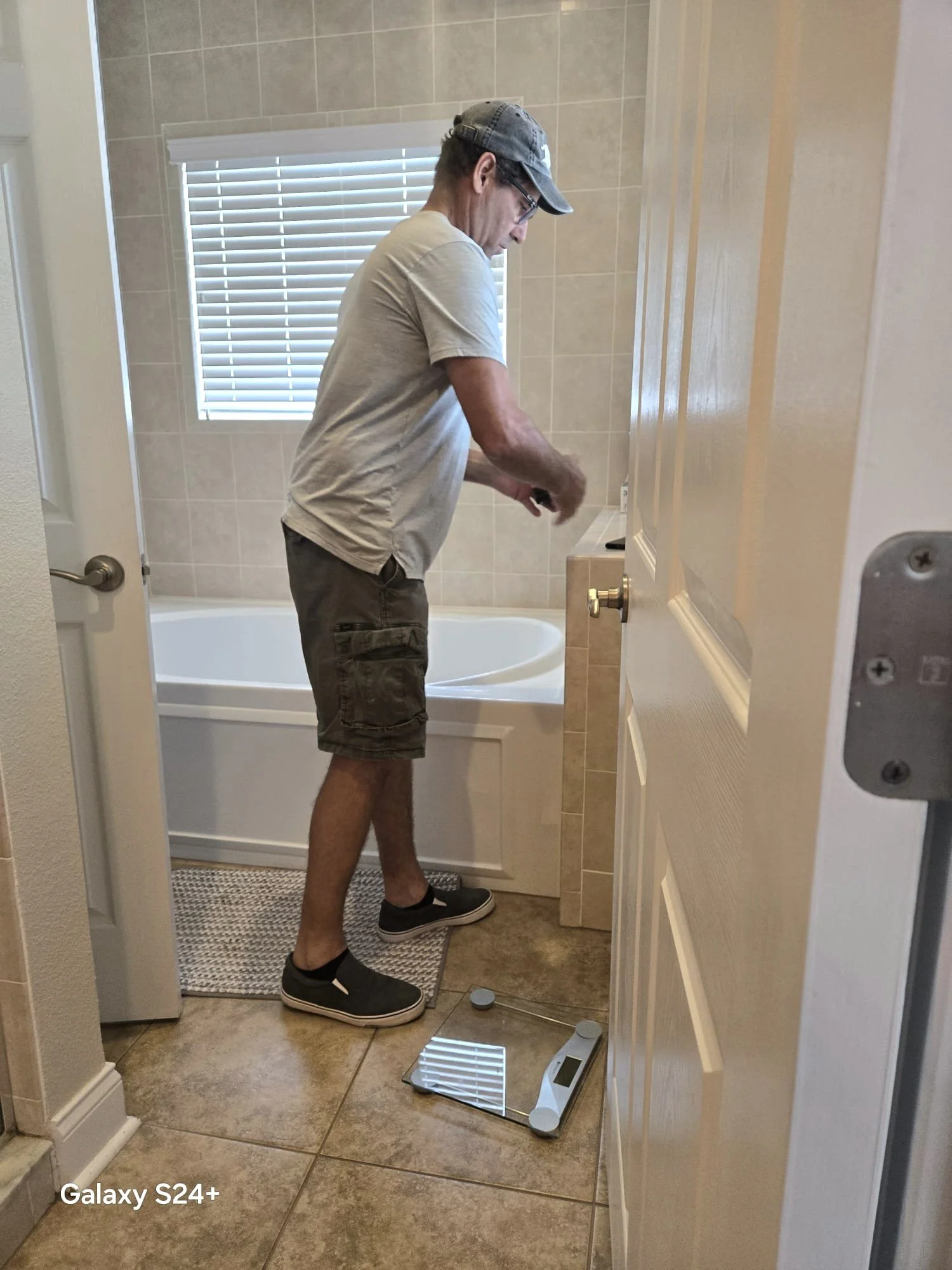 A man standing fixing bathroom floors