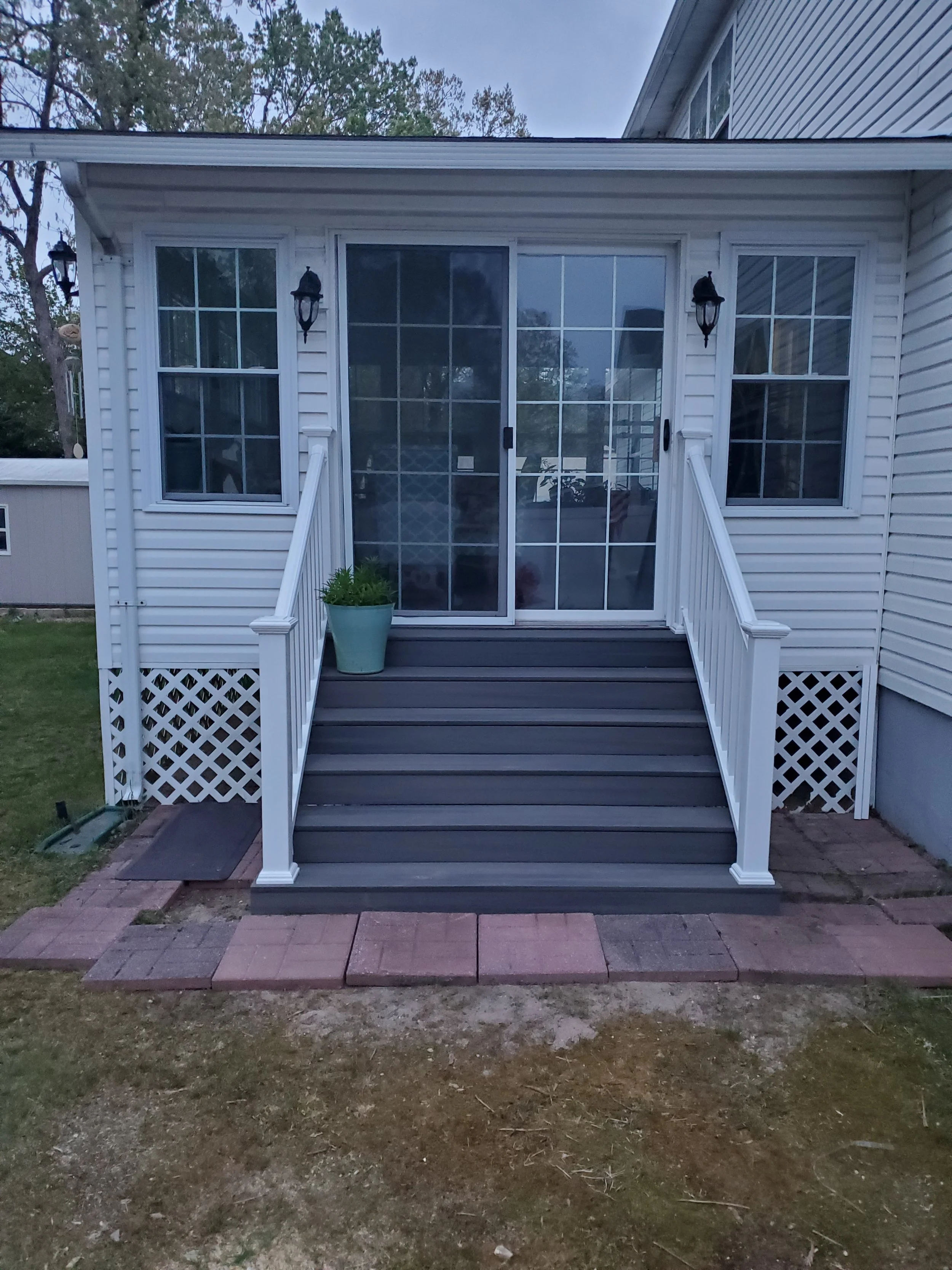 Backyard wooden deck with stairs.