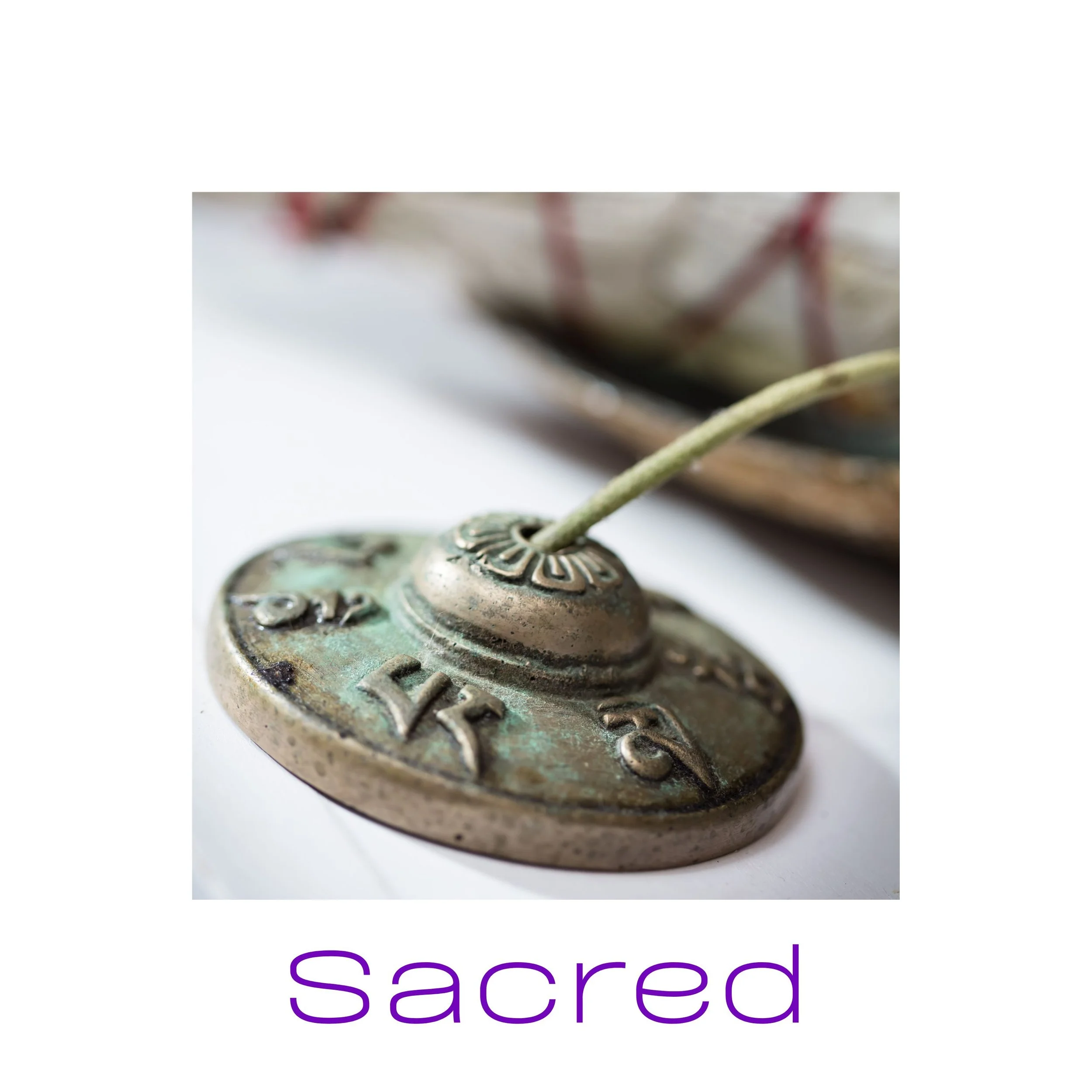 Bronze incense holder with engraved symbols and text "Sacred" below.
