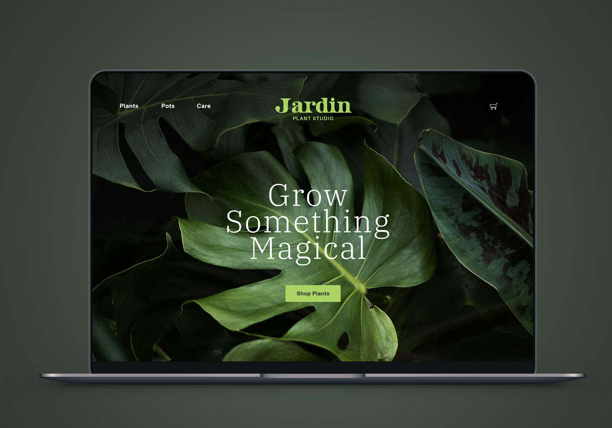 Laptop screen displaying a website for a plant studio called Jardin with a background of green leaves and the text "Grow Something Magical" and a button labeled "Shop Plants."
