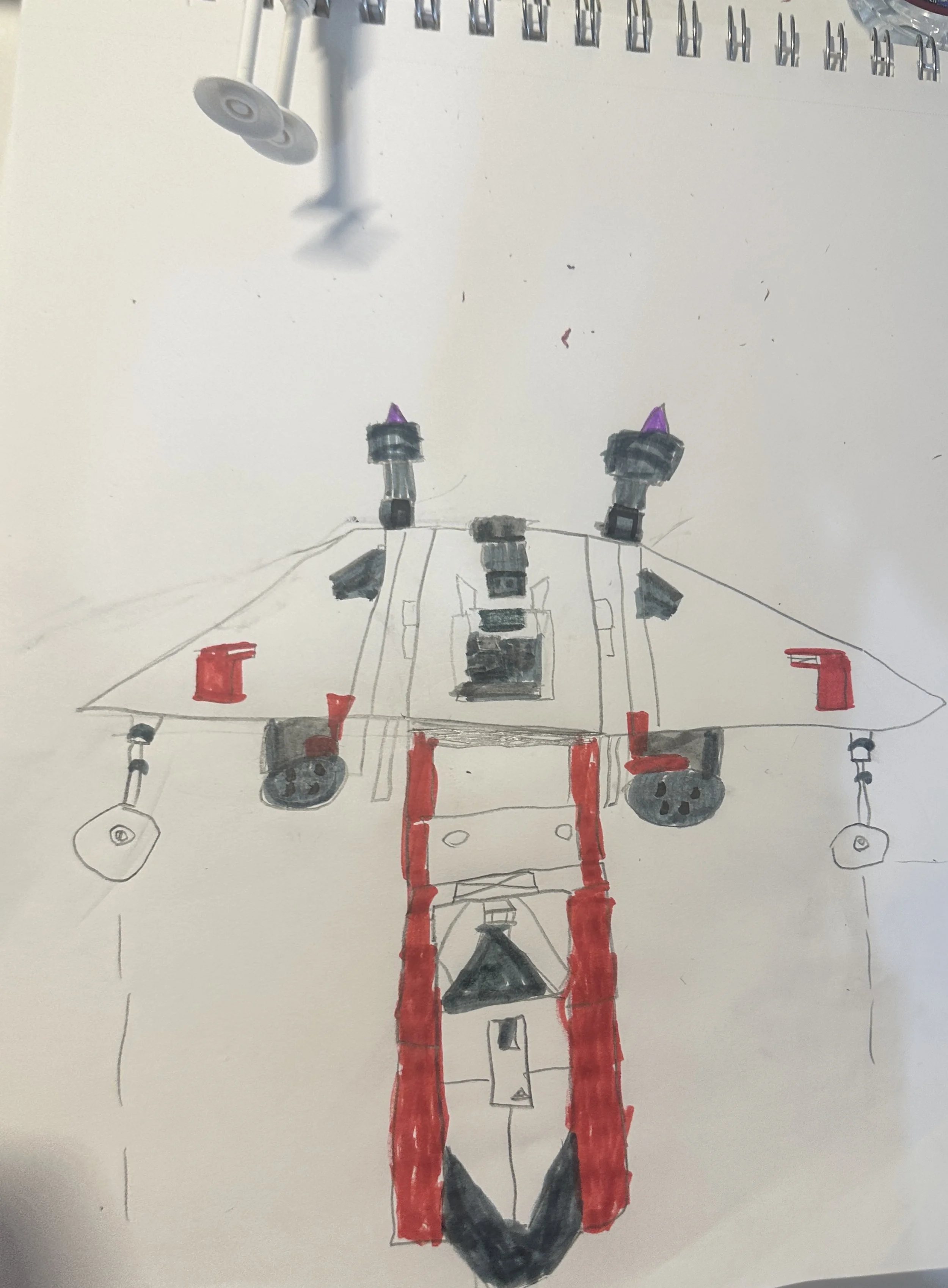 A hand-drawn sketch of a large robot or vehicle with red, black, and purple details, drawn with markers or pens on a white sheet of paper.