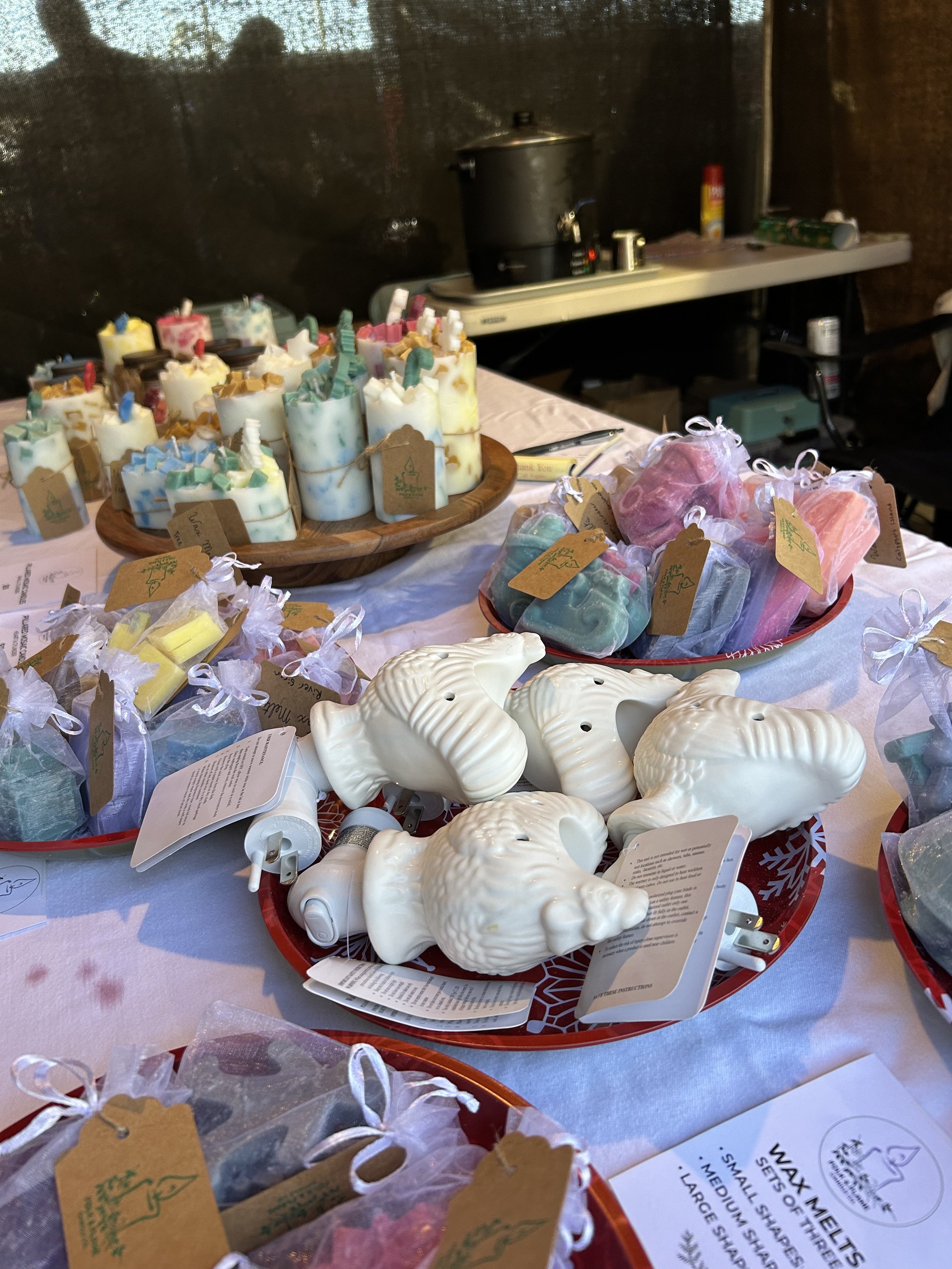 Display at a local San Diego Christmas market including rooster wax melters, handmade wax melts, and pre-made "mosaic" pillar candles.