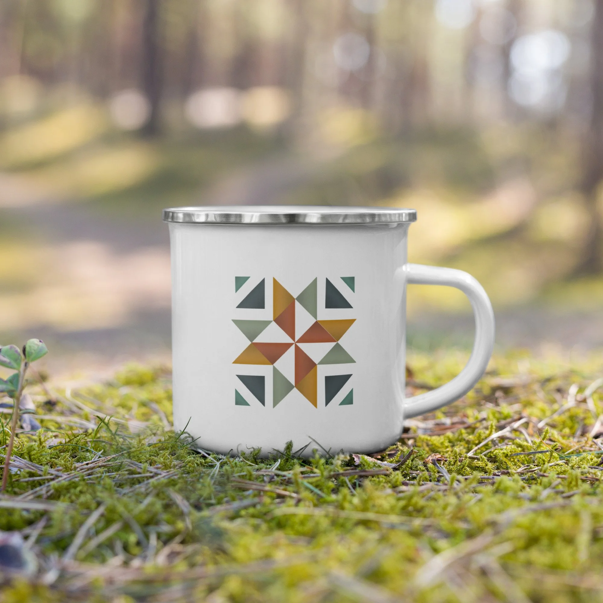 A beautiful white camping mug with a silver lip and a fun quilt block square on the front and back.