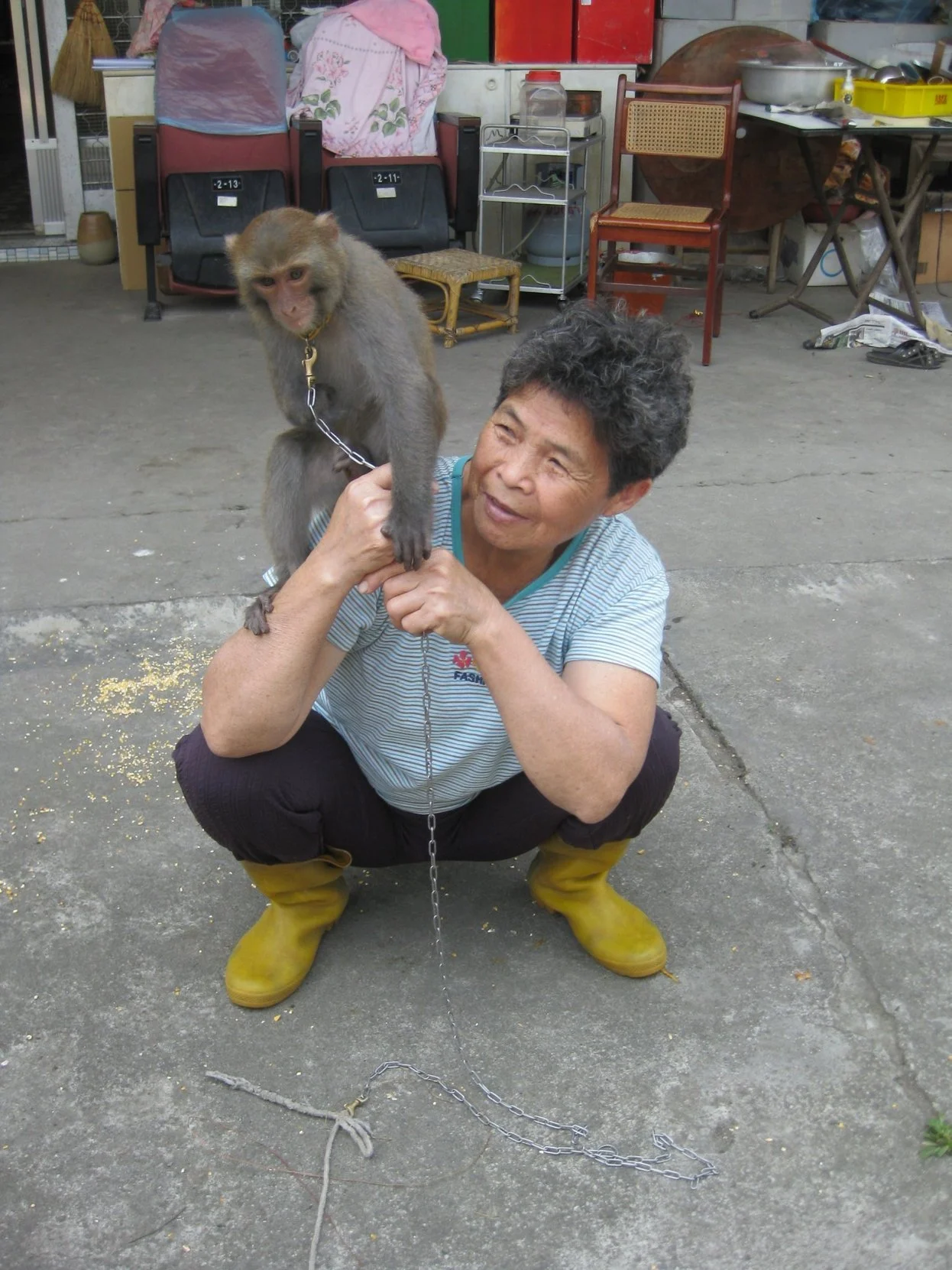 A woman proudly displays her pet monkey sitting on her shoulder during a Cultural Experience with Tricia Pomering in Taiwan.