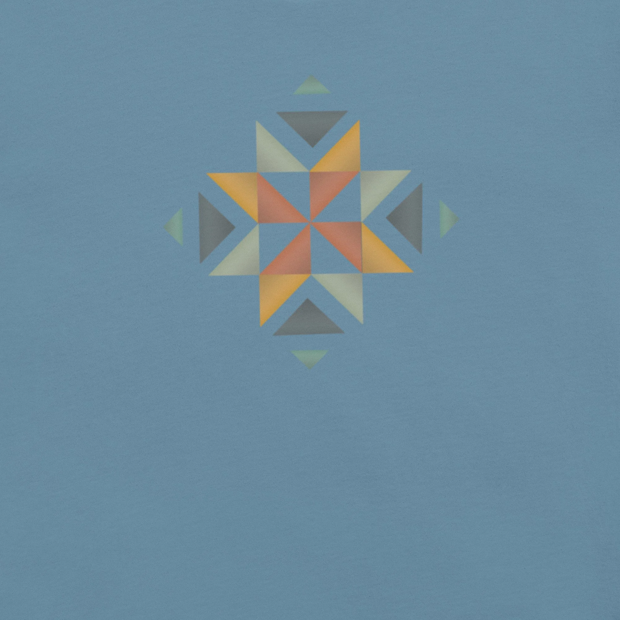 The front of a blue shirt with a beautifully designed quilt block in multiple colors on the front.