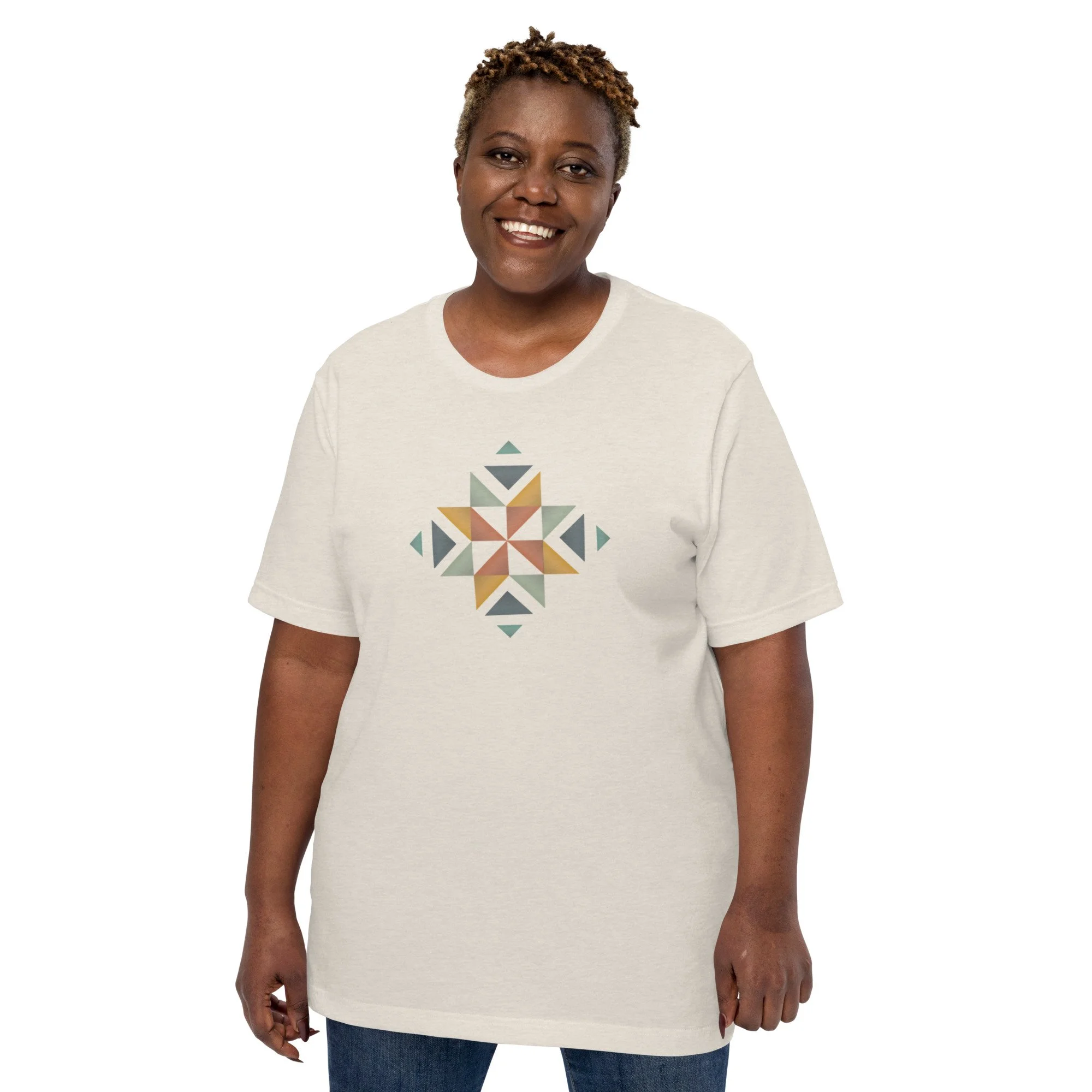 A woman wearing a white shirt with a beautifully designed quilt block in multiple colors on the front.