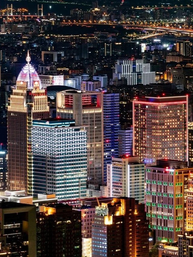 Evening city skyline in Taiwan with lights illuminating the urban landscape.