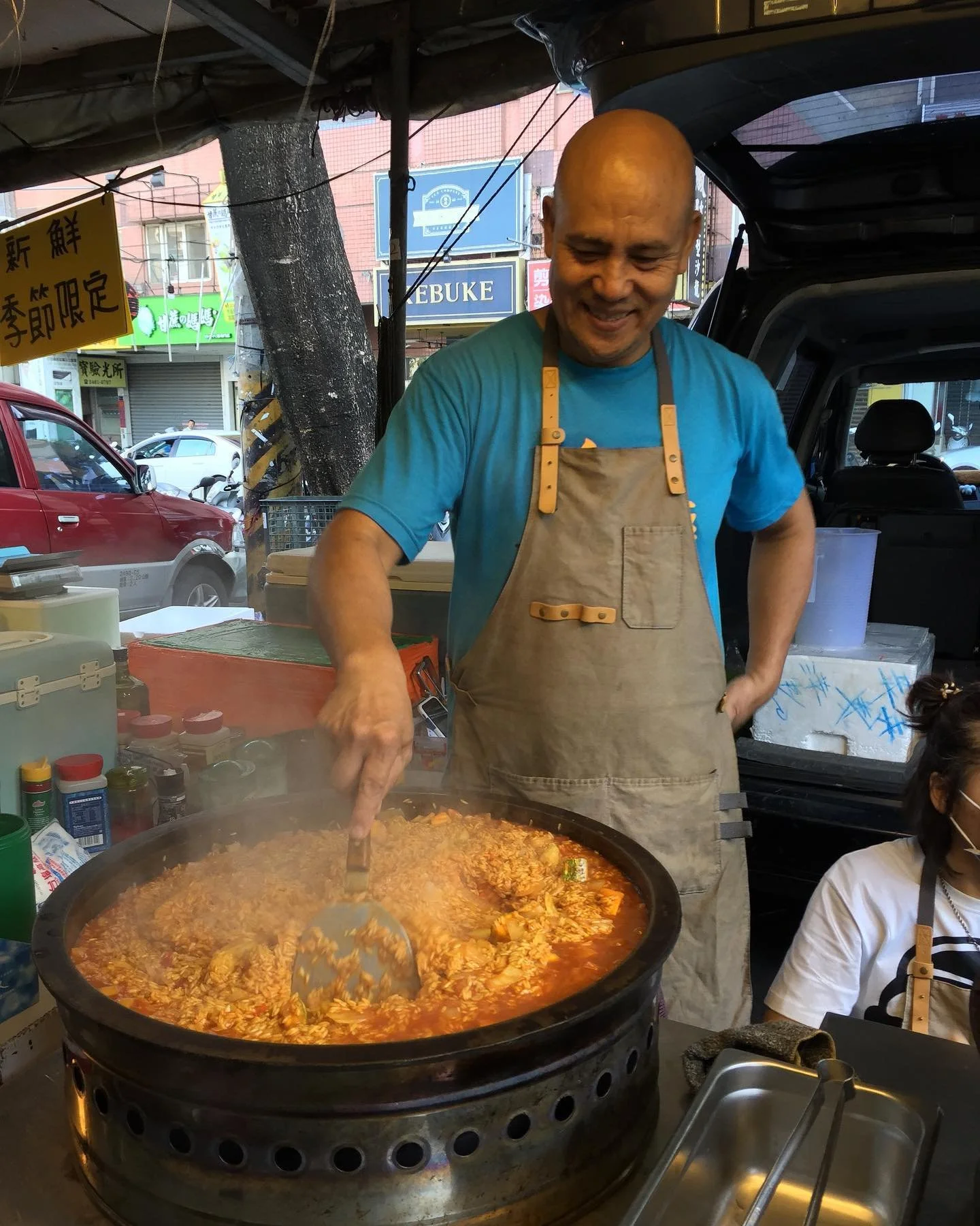 A man making a large pot of food in an evening open air market in Taiwan during a Tricia Pomering Cultural Experience.