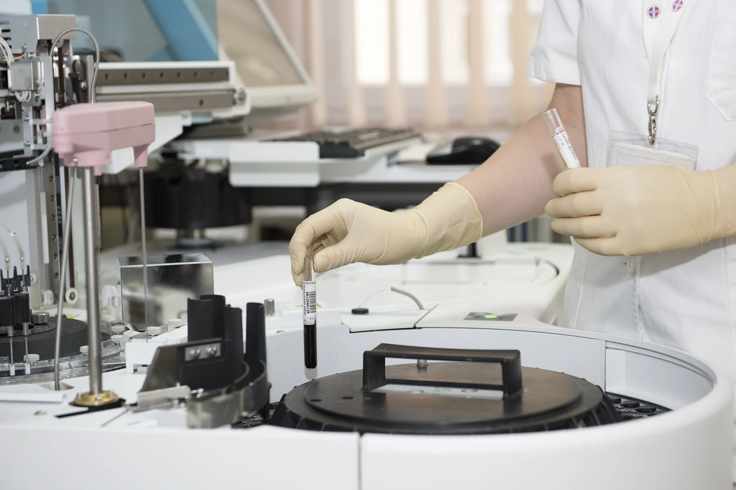 Laboratory technician reviewing a blood sample as part of a comprehensive health screening in Taiwan.