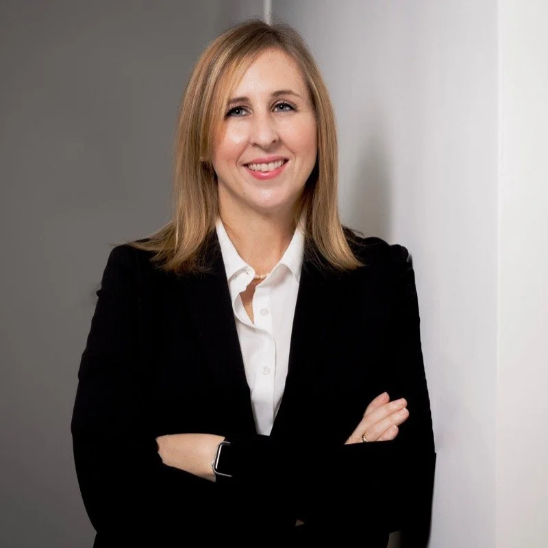 Beth Eckstein stands in a suit as an executive coach specializing in cultural awareness. She joins Tricia Pomering on cultural immersion retreats to Taiwan.