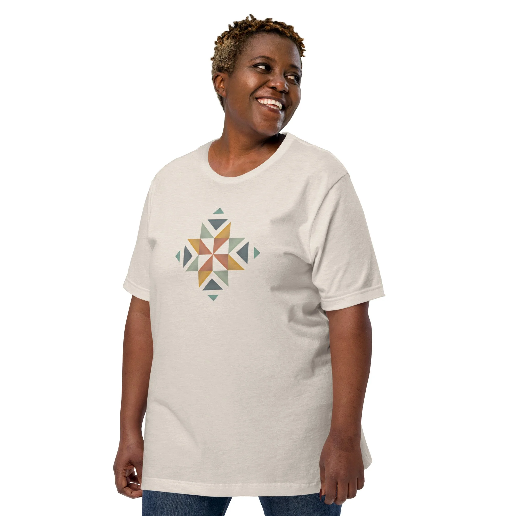 A woman wearing a white shirt with a beautifully designed quilt block in multiple colors on the front.